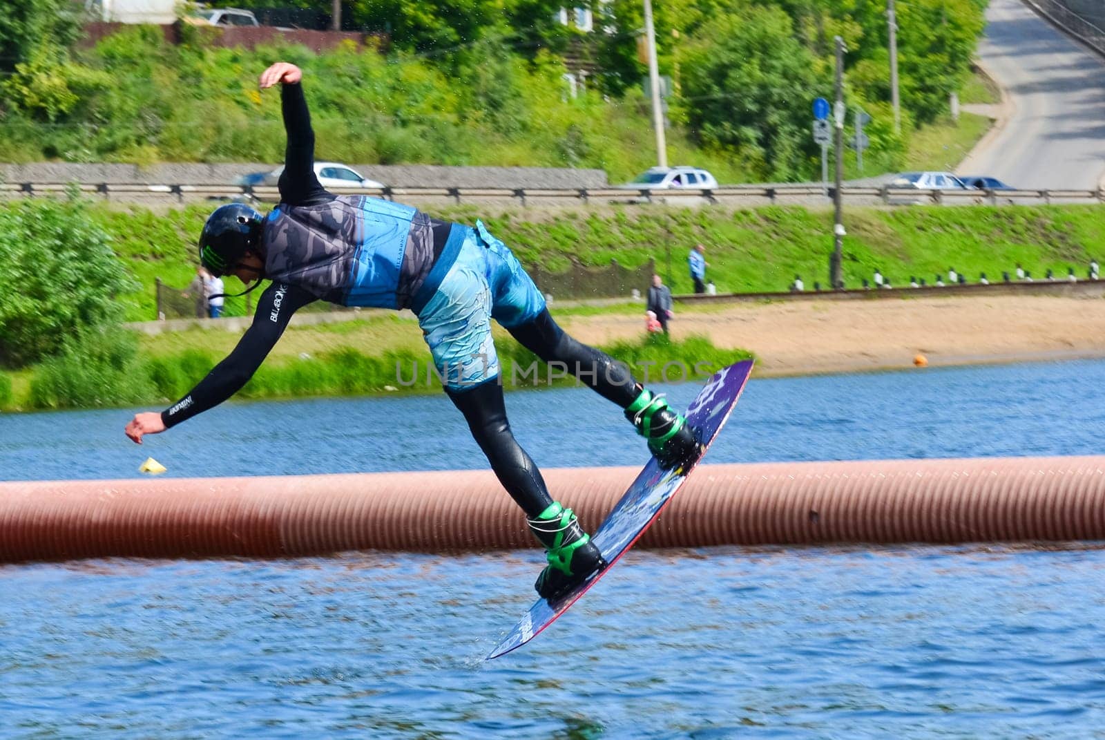 Russia, Volgodonsk - June 18, 2015: Water snowboard. The athlete with snowboard hold on to the rope and the boat accelerates.