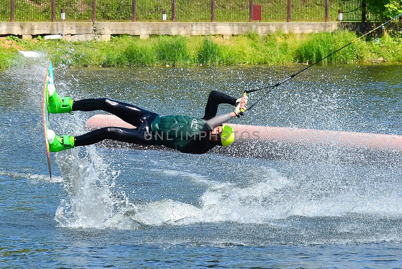 Russia, Volgodonsk - June 18, 2015: Water snowboard. The athlete with snowboard hold on to the rope and the boat accelerates.