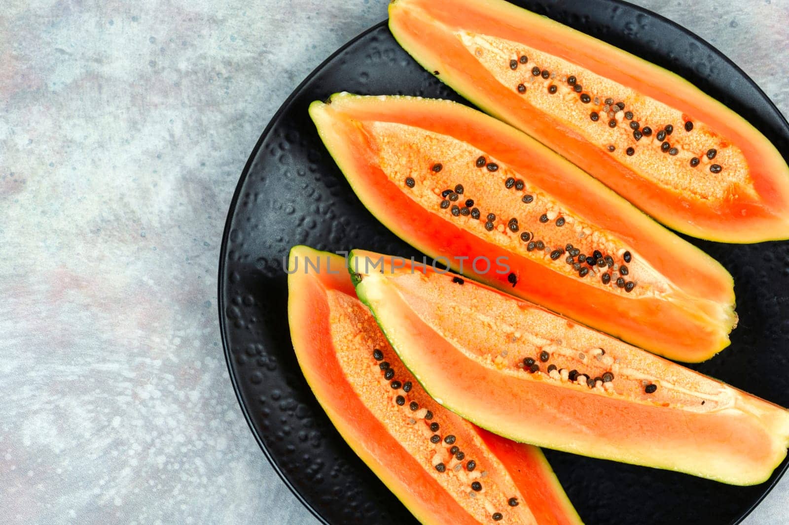 Sliced fresh juicy papaya on the table. Papaya exotic fruits. Top view.