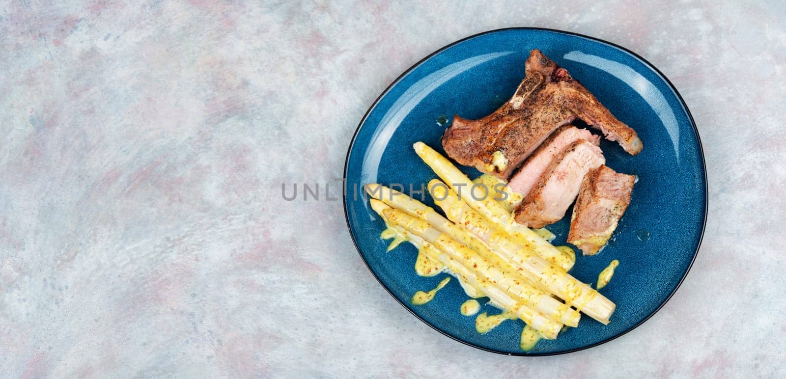 Juicy fried meat steak with boiled white asparagus.