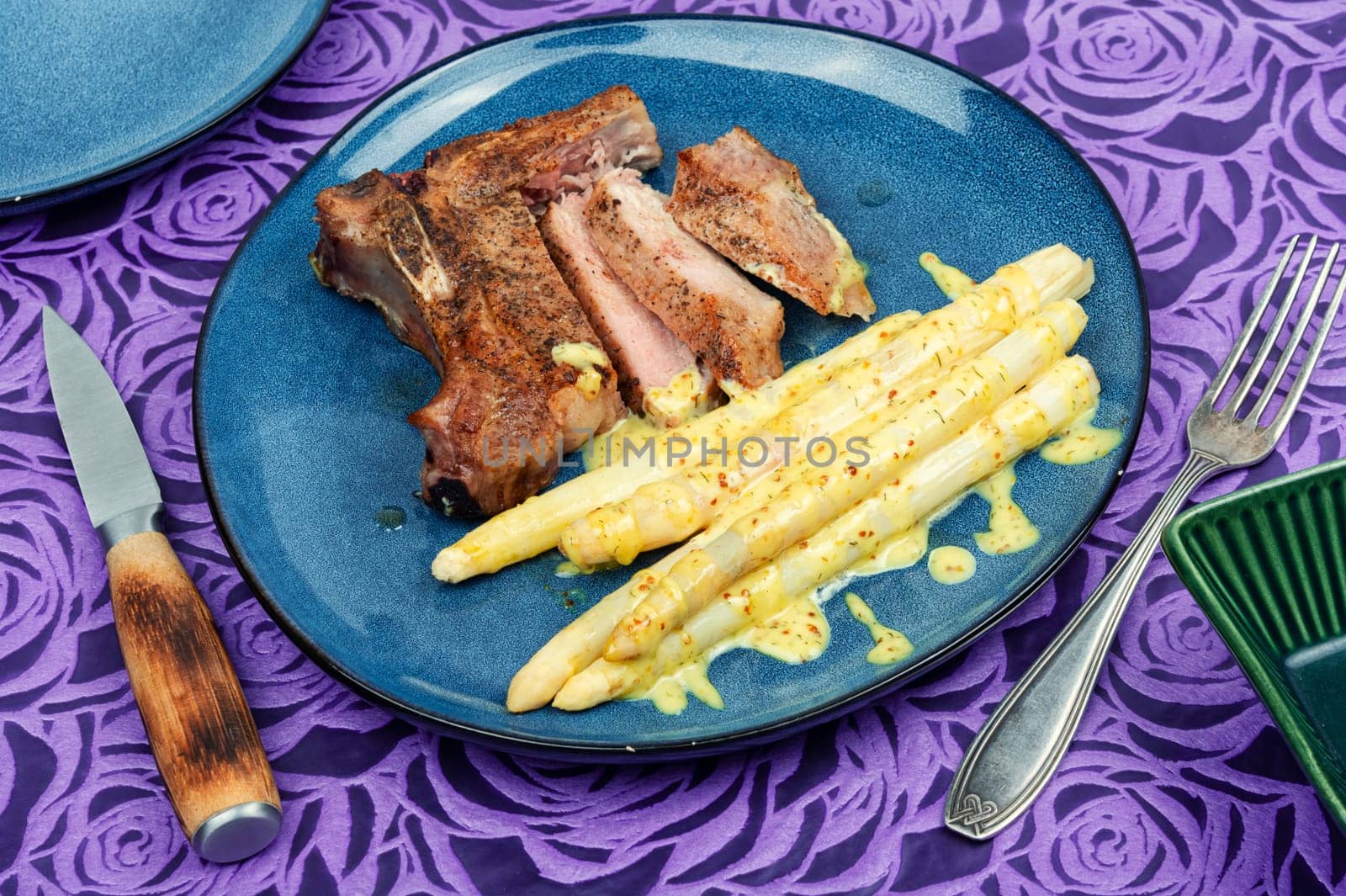 Juicy fried meat steak with boiled white asparagus.