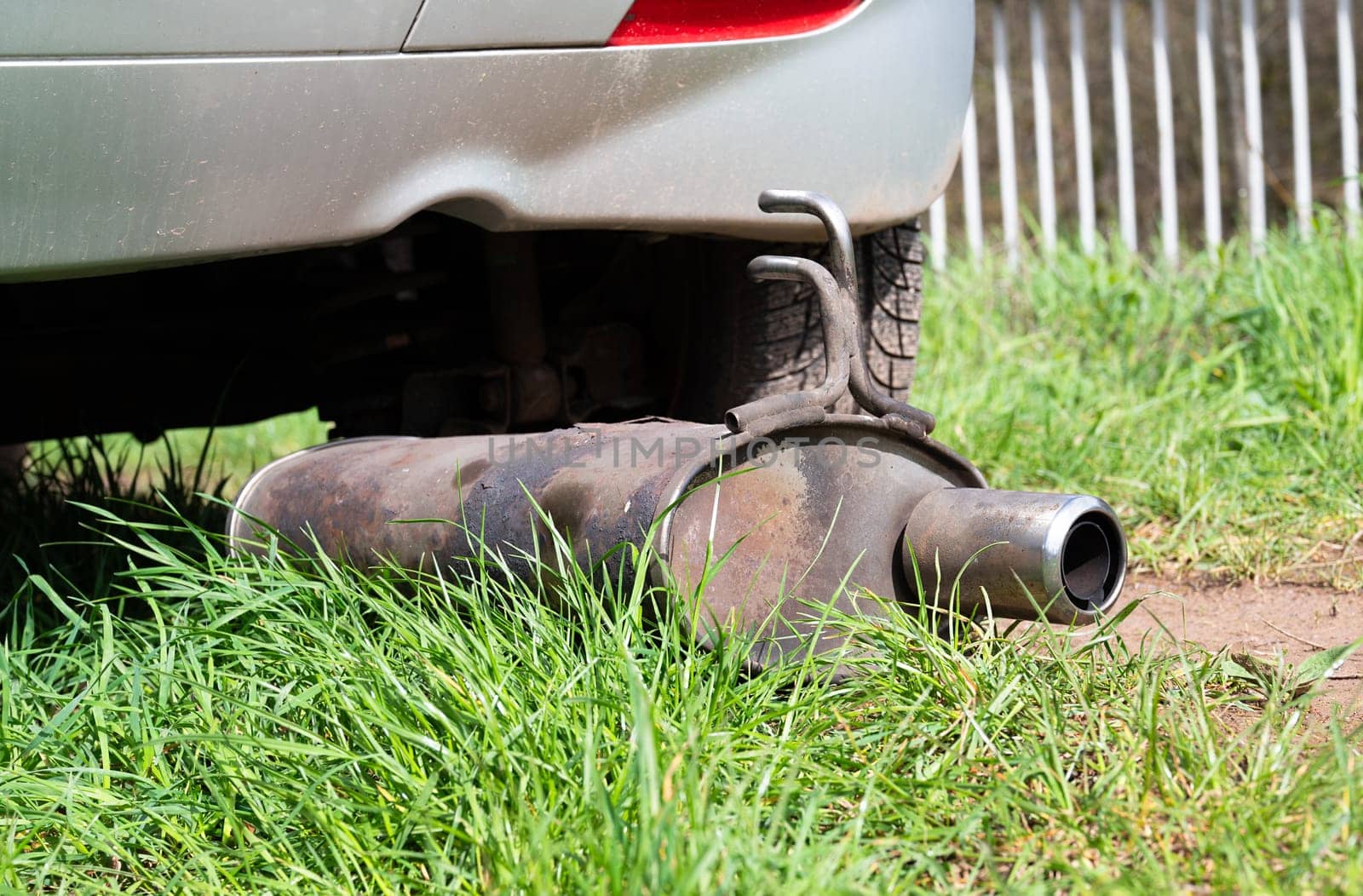 Broken exhaust and muffler of a car, rusted silencer fallen down on the road, breakdown of vehicle