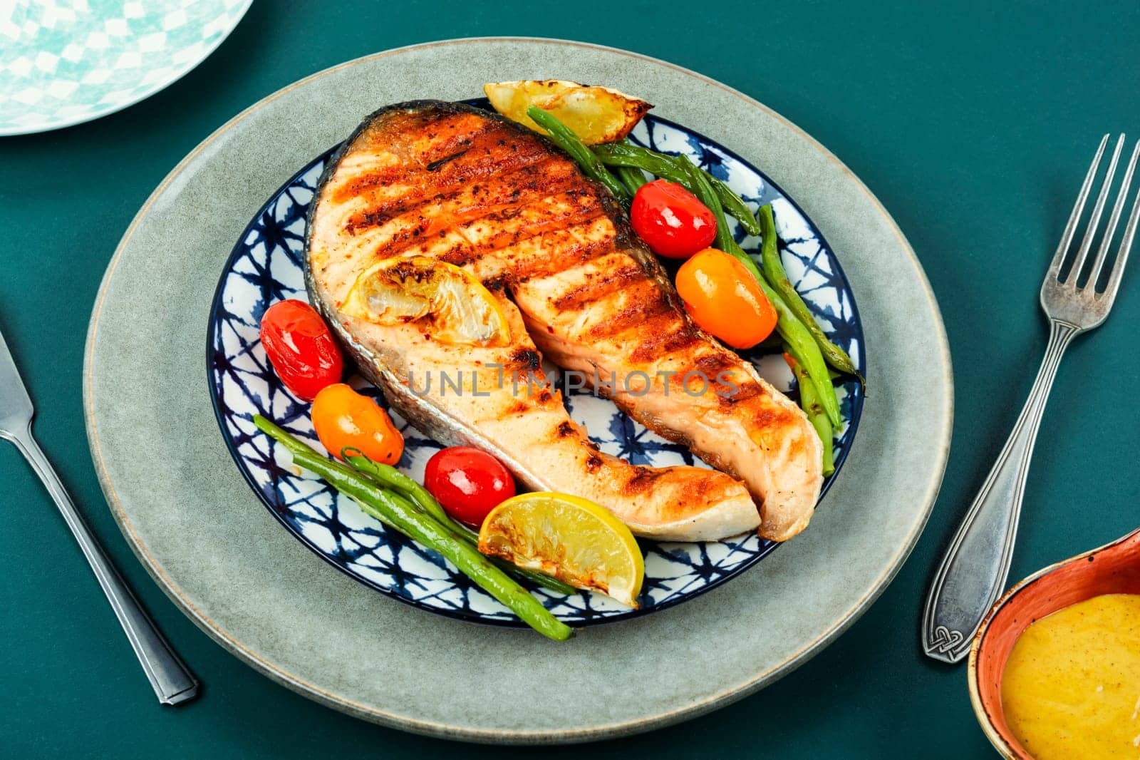 Fried salmon steak and grilled potatoes and green beans. Grilled fish.