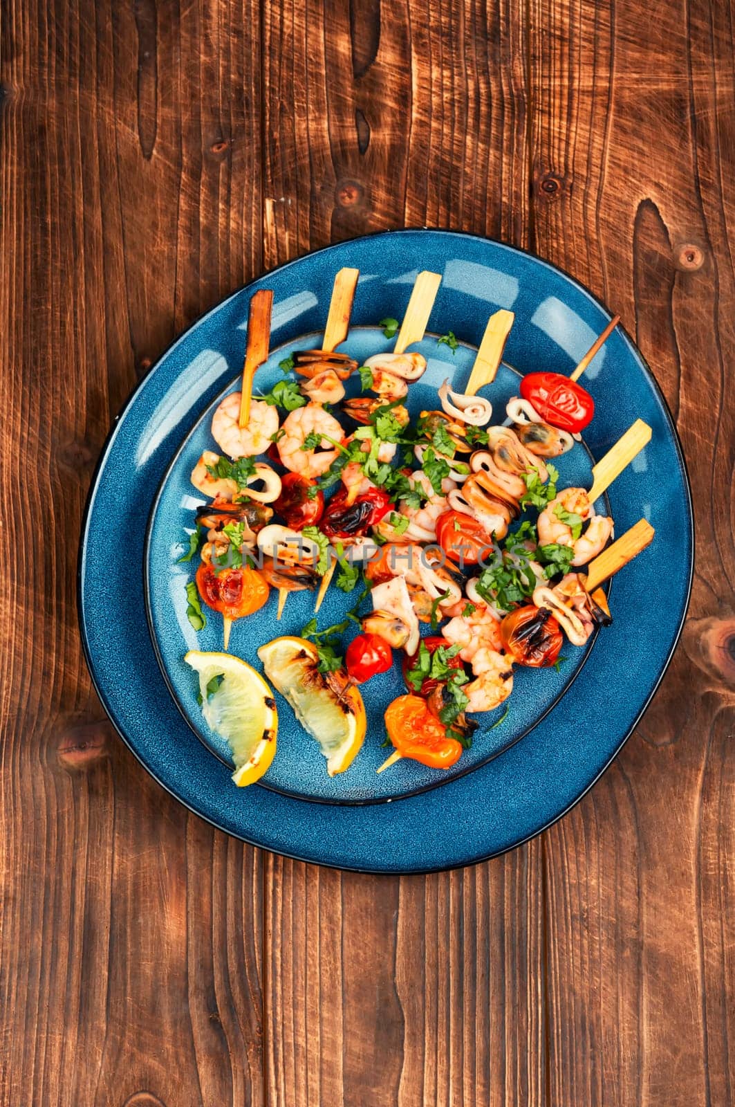 Grilled squid, fried mussels and shrimp on wooden skewers. Seafood appetizers.