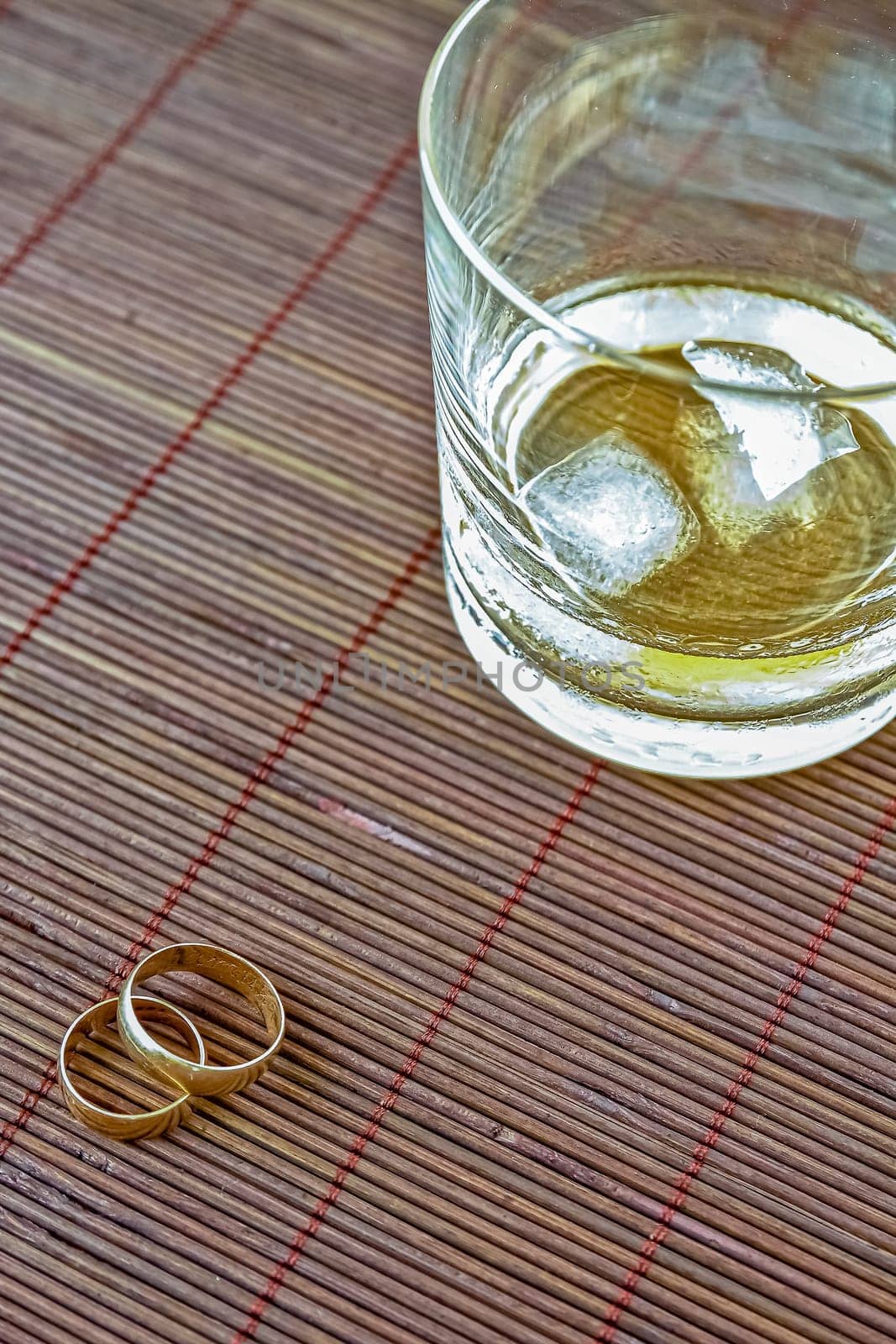 Wedding rings and a glass of alcohol. Selective focus with shallow depth of field.