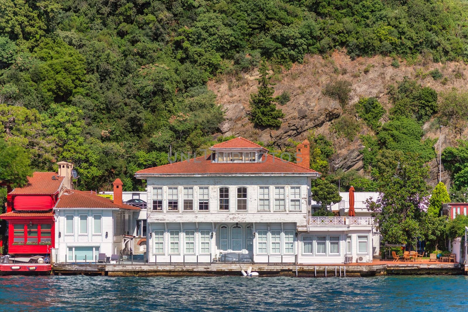 View from Bosphorus strait of the green mountains of the Asian side, with traditional houses and dense trees in a summer day, Istanbul, Turkey