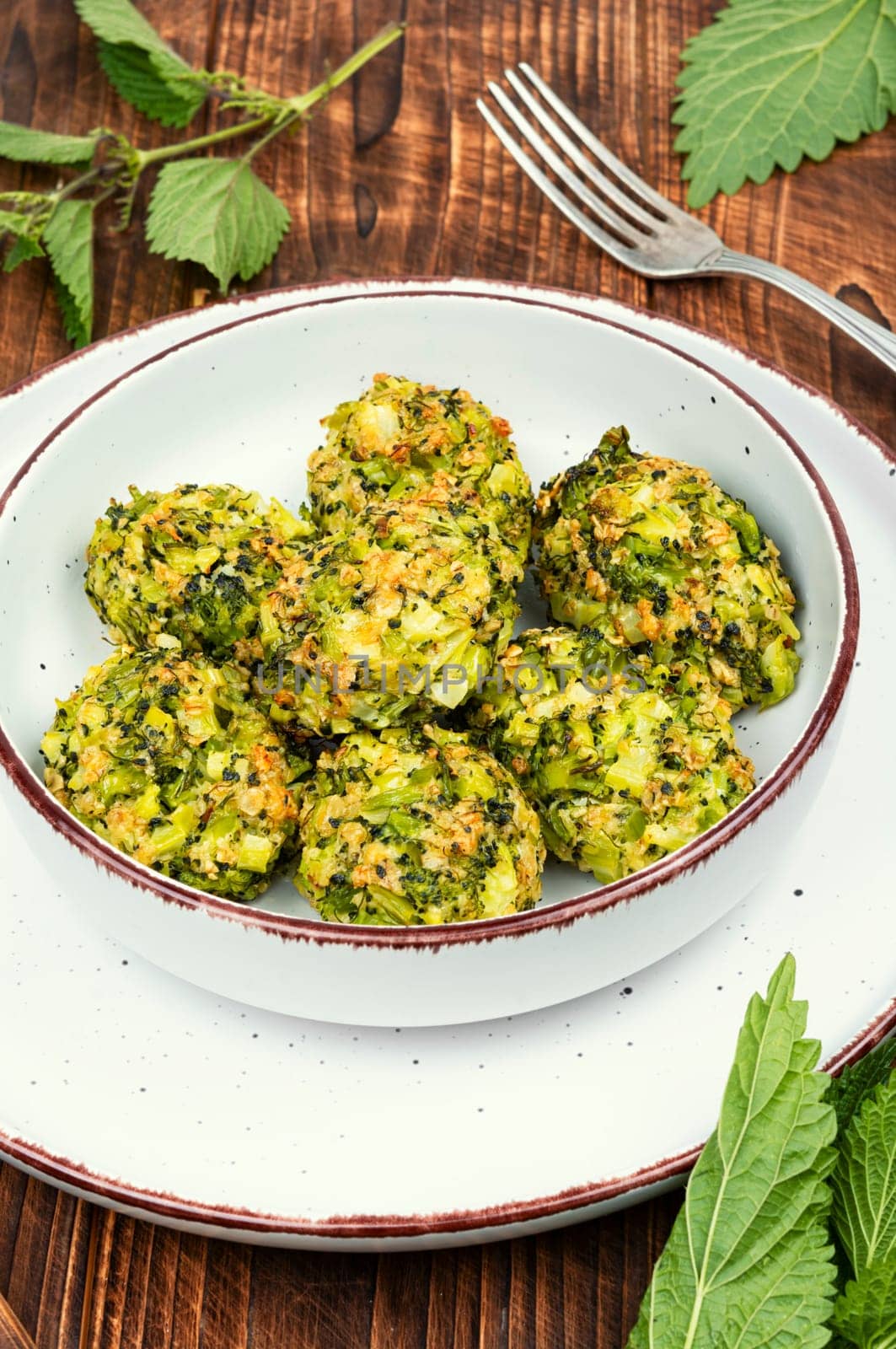 Vegetarian cutlets of cutlet nettles leaves and broccoli. Fried nettle meat balls on wooden rustic table