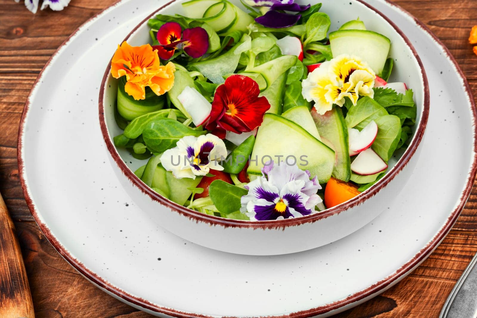 Raw fresh salad of cucumber, radish, green and flowers. Clean and healthy eating concept. Space for text.
