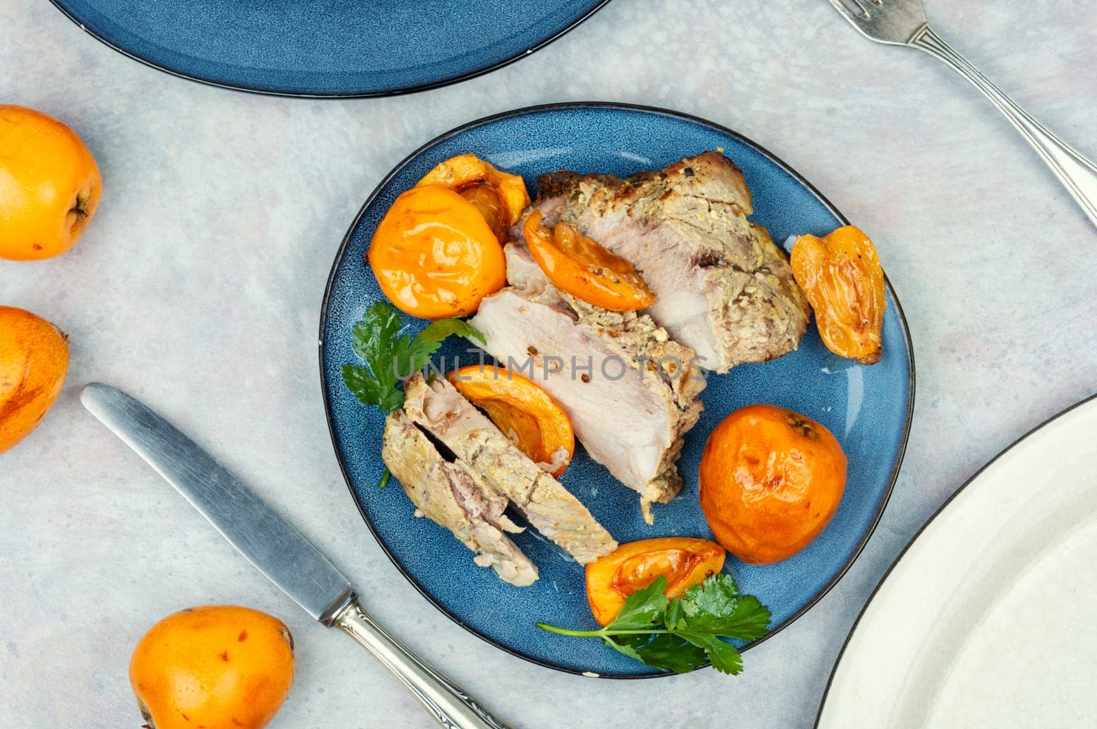 Roasted barbecue tenderloin meat with succulent loquat fruits. Delicious piece of meat roasted with ripe medlar fruit