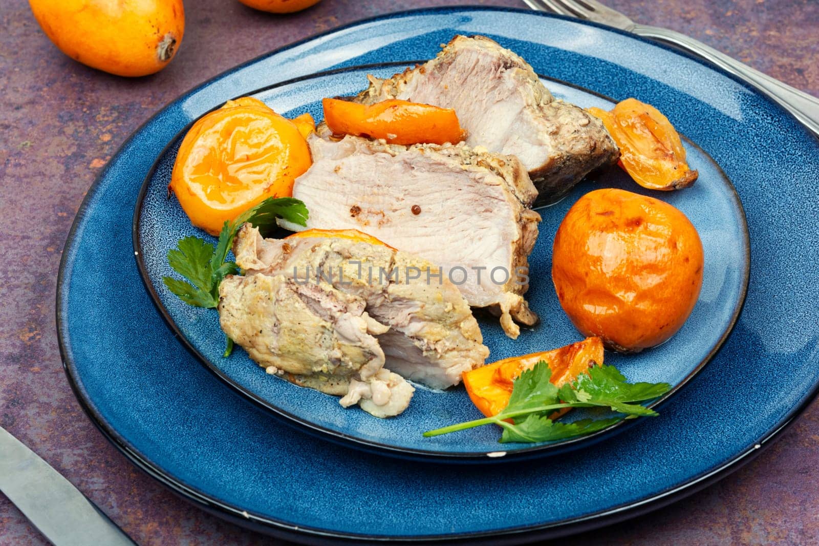 Roasted barbecue tenderloin meat with succulent loquat fruits. Delicious piece of meat roasted with ripe medlar fruit