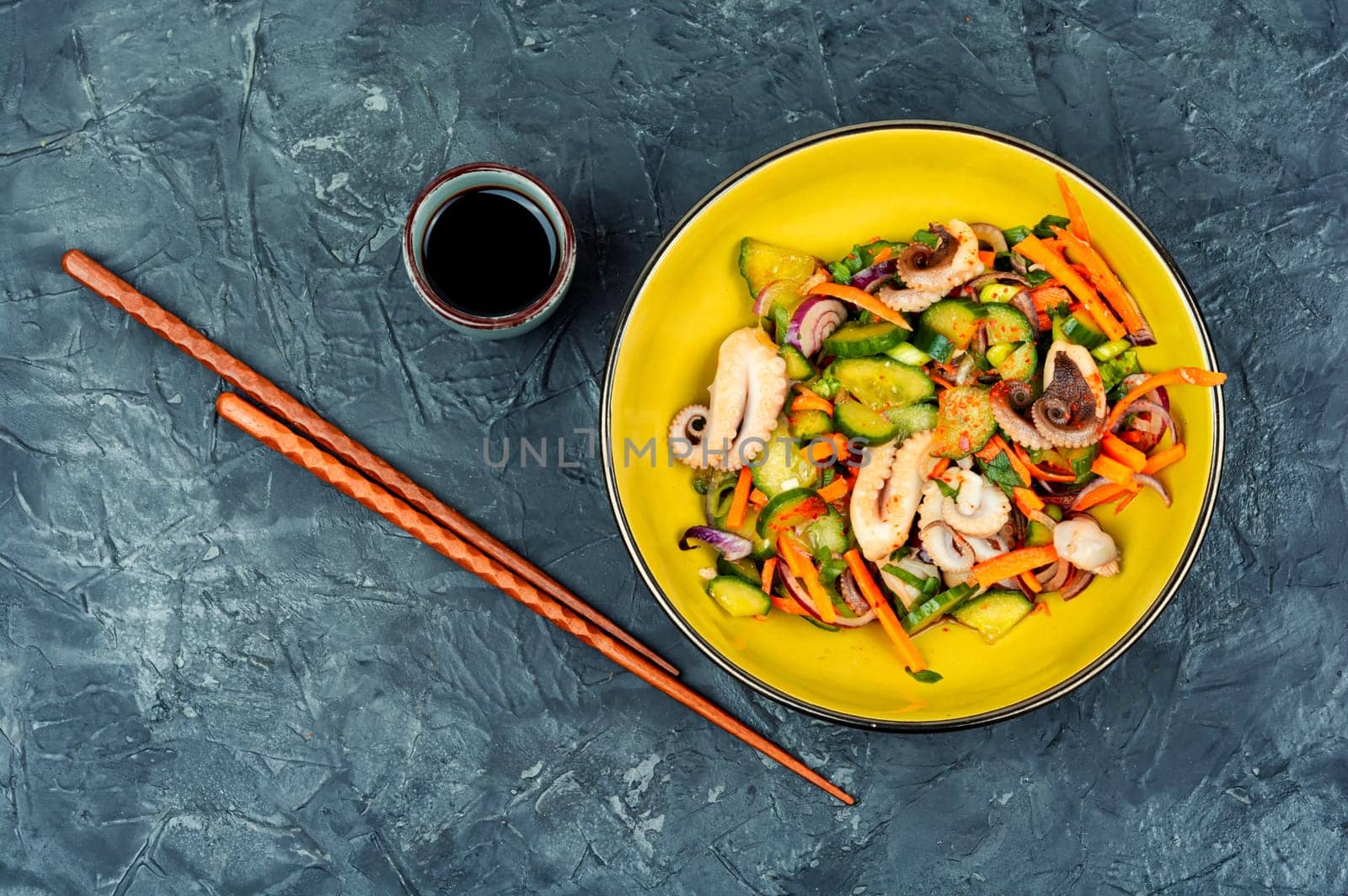 Salad of cucumber, onion and octopus. Korean food. Korean cuisine with seafood. Copy space.