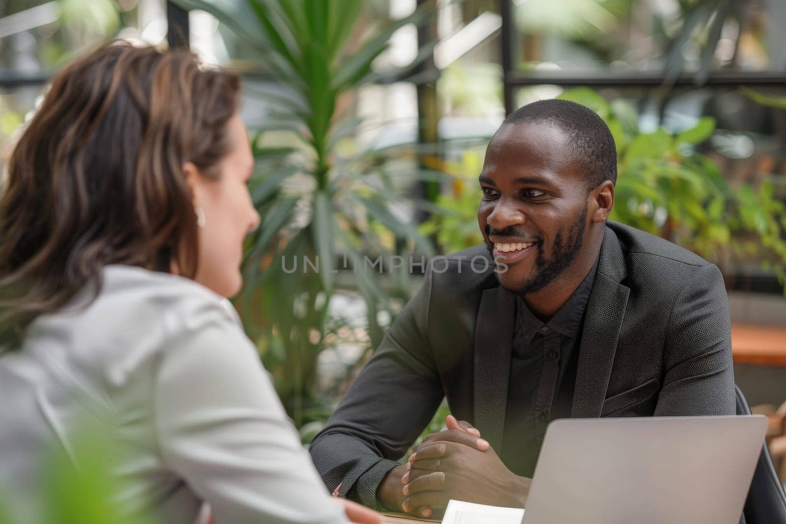 A man and woman engage in a lively conversation while sitting at a table.