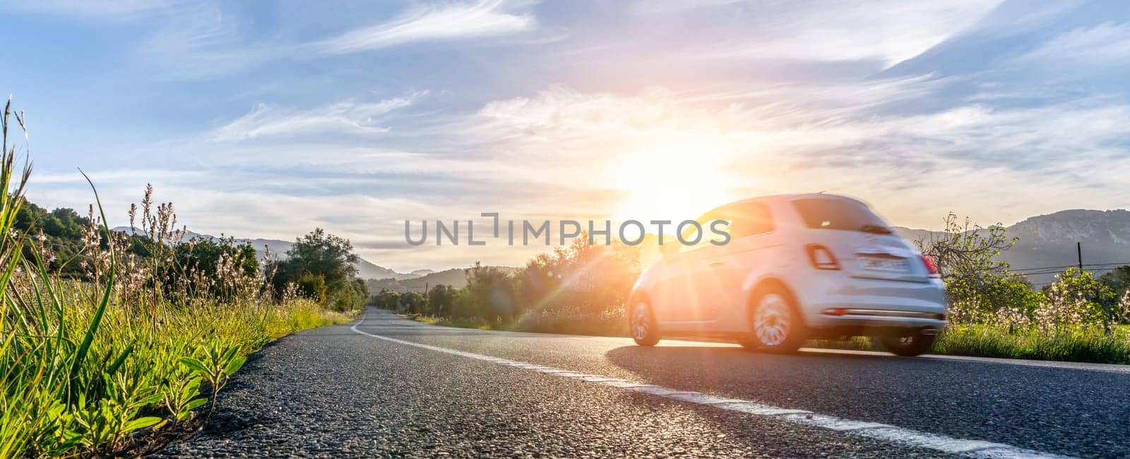 rental car in spain mountain landscape road at sunset - wide angle panorama shot