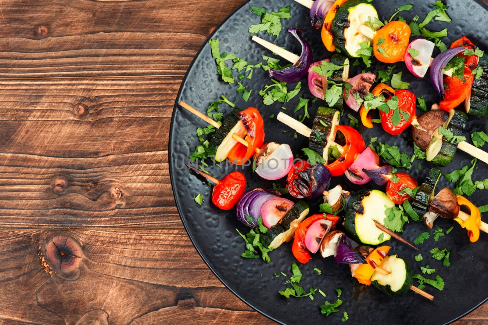 Vegan shashlik of fresh vegetables on wooden skewers. Copy space. Space for text.