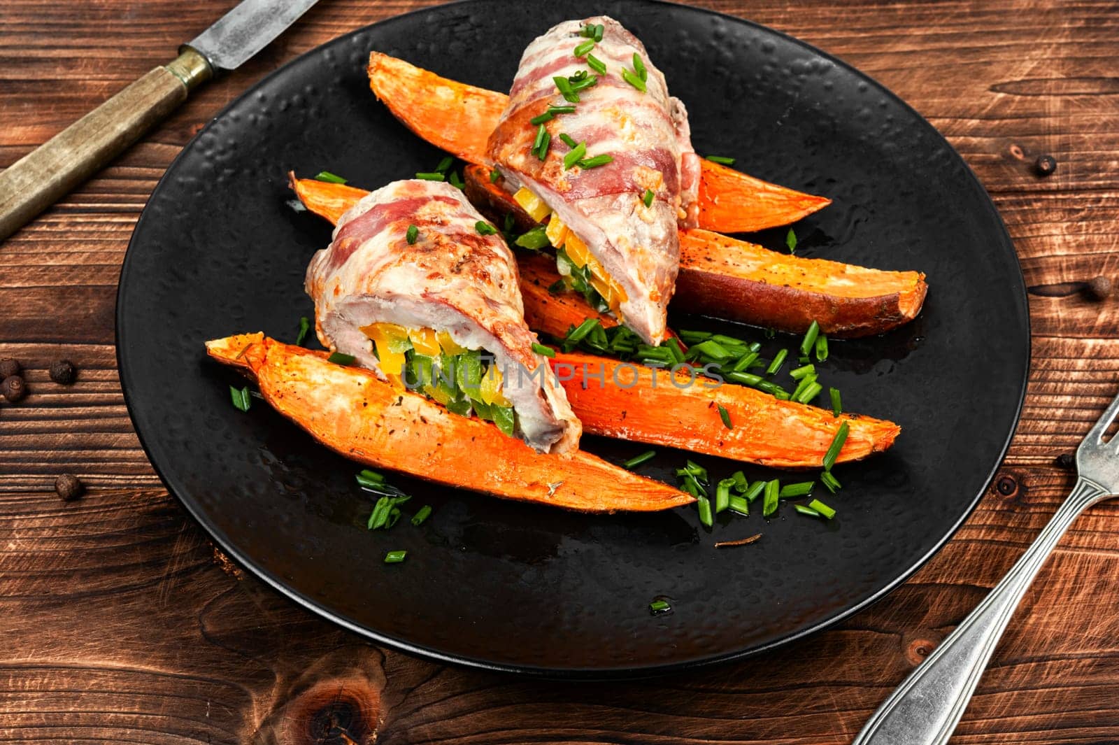 Grilled meat rolls wrapped in strips of bacon served with baked sweet potatoes.