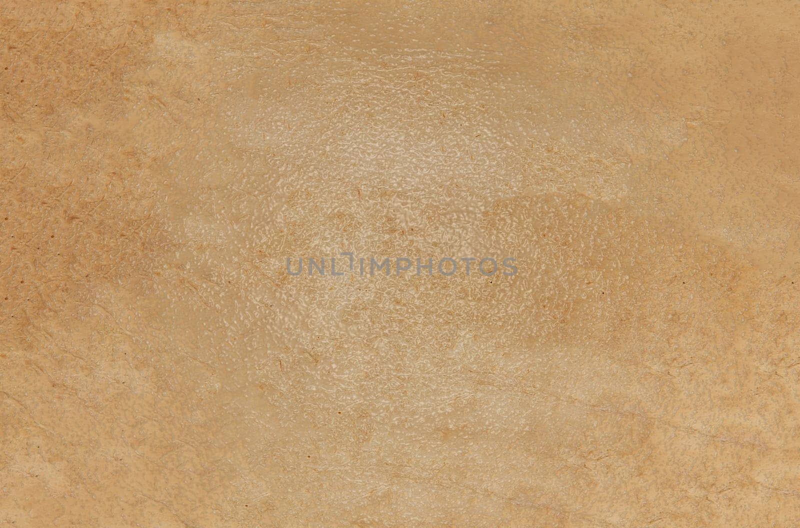 The background texture is a rough brown glossy surface with streaks and spots in close-up