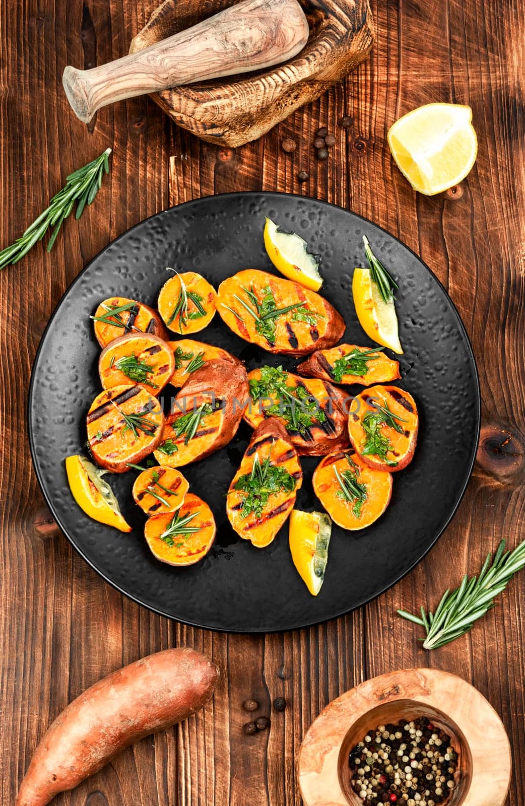 Homemade grilled sweet potato, batata with olive oil and herbs. Vegan cuisine.