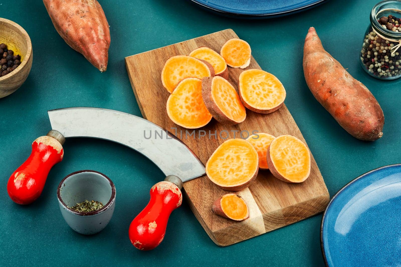Sweet potatoes or batatas, board and knife . Dietary food. Vegetables.