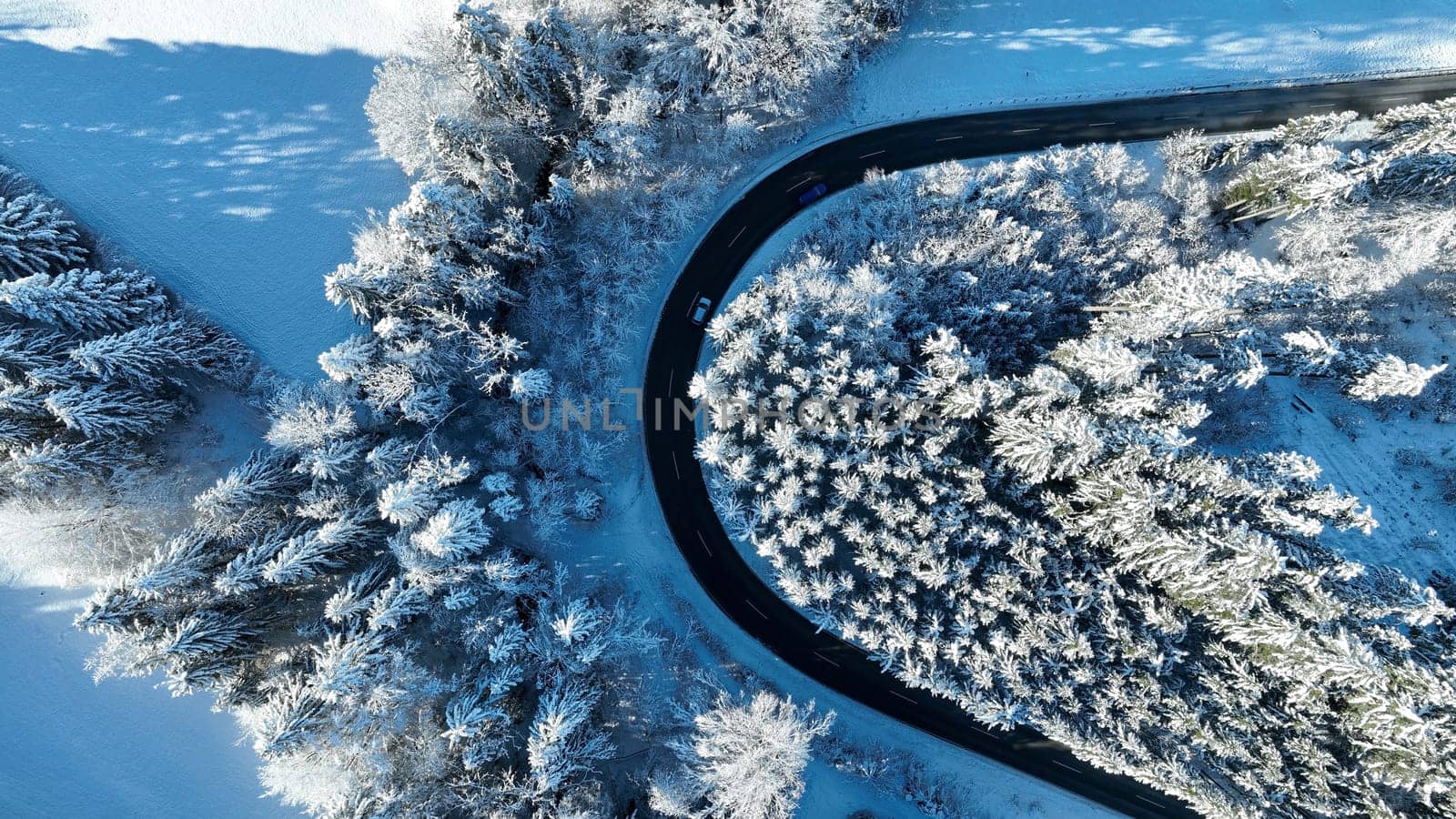Drone photo of a sharp bend in the road with traffic in winter