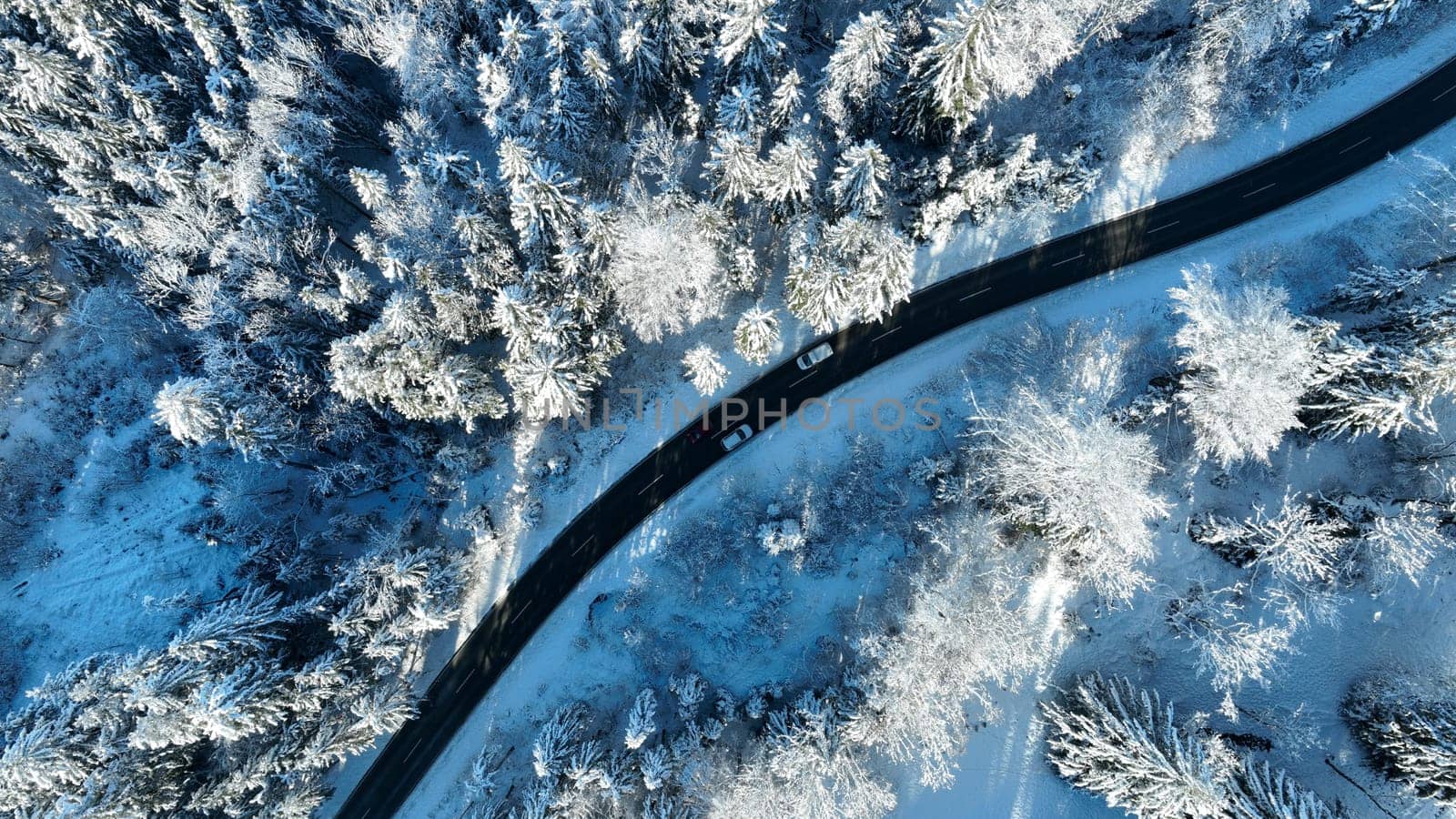 Drone photo of a sharp bend in the road with traffic in winter