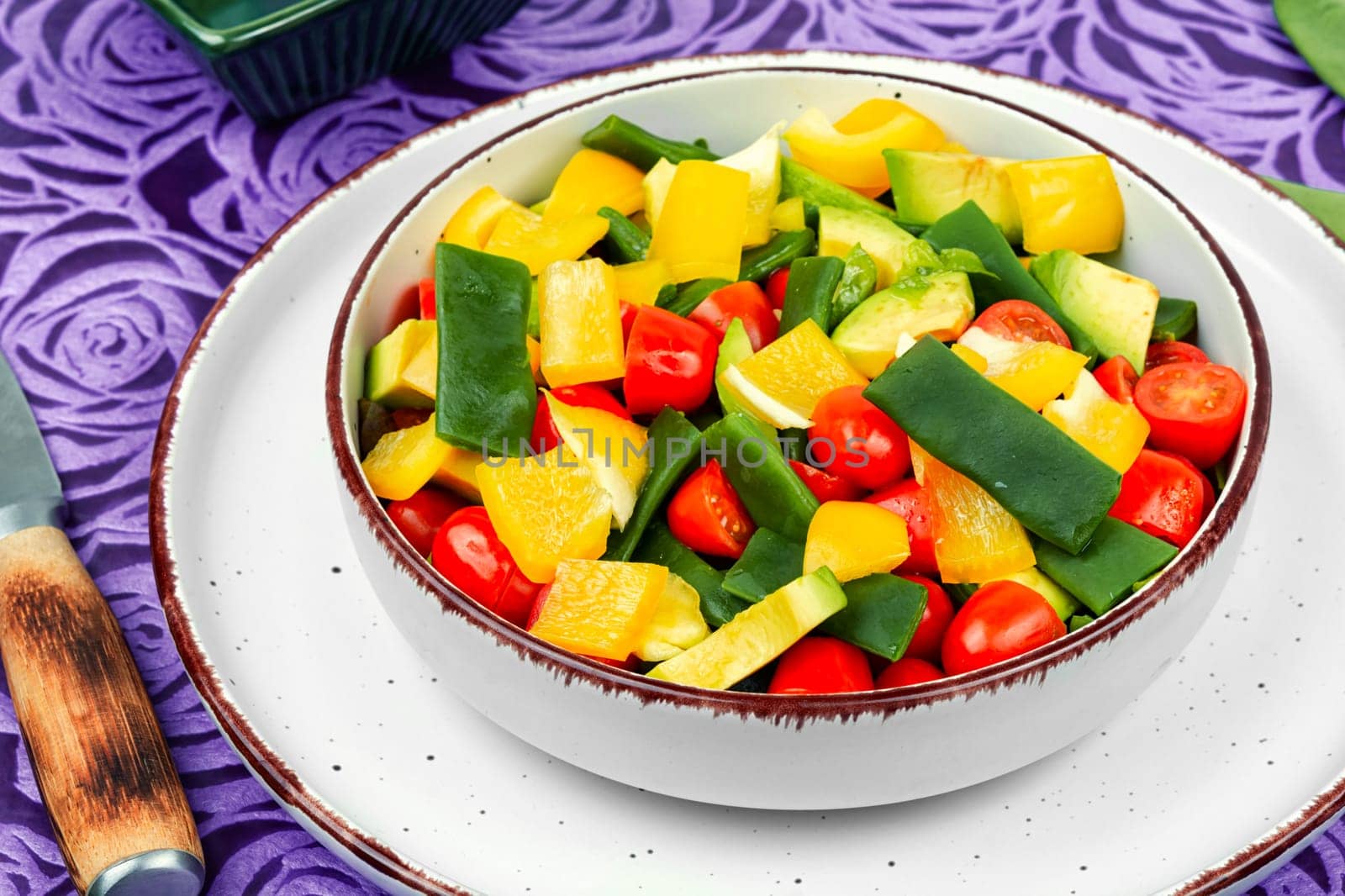 Fresh vegetable salad with bell pepper, tomato, avocado and runner beans or green bean.