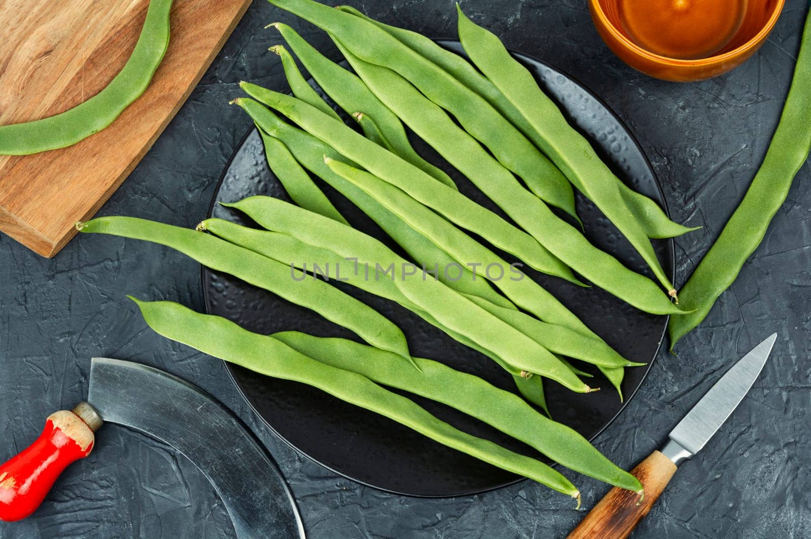 Fresh runner beans and a grass knife. Green Romano beans. Top view