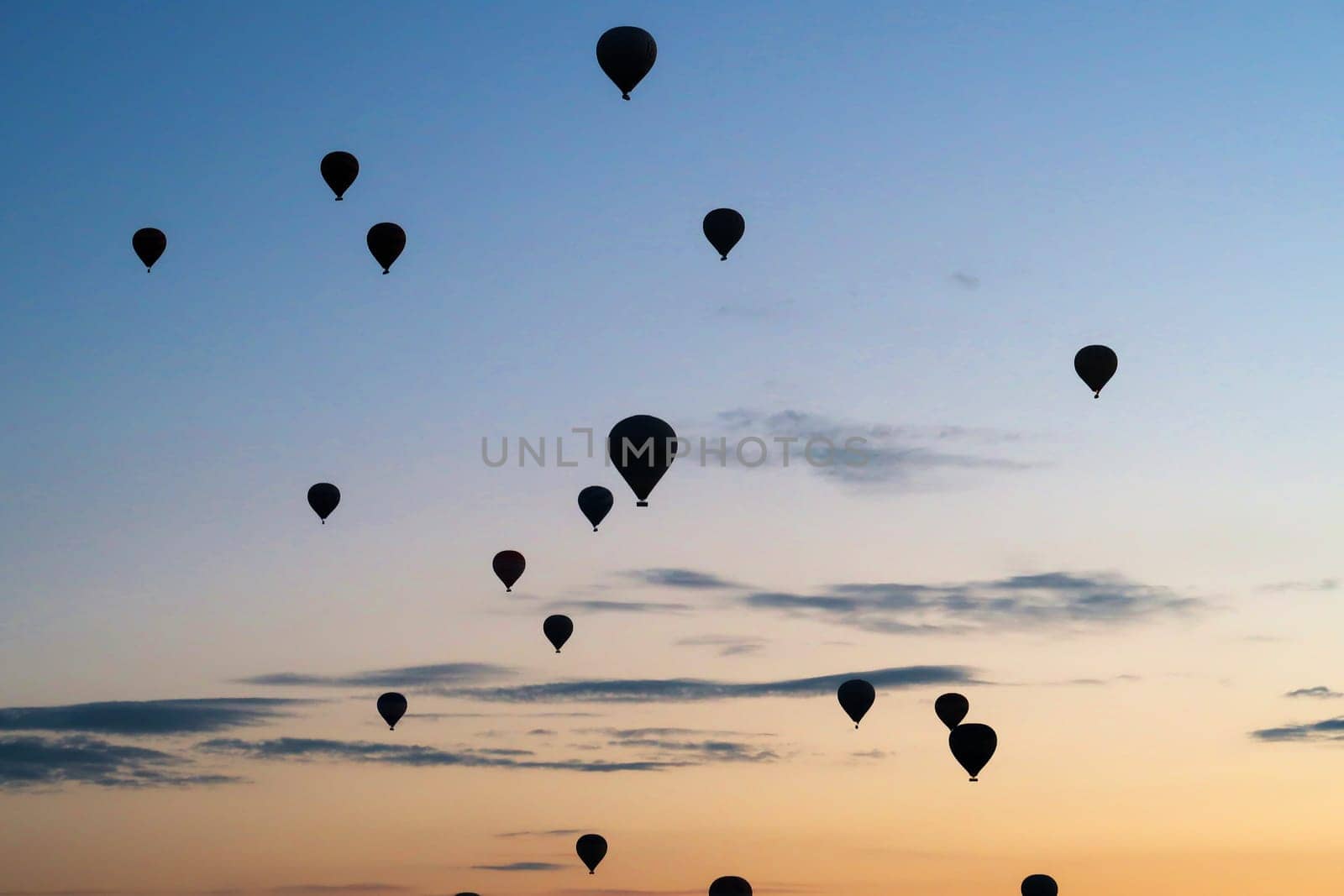 Many hot air balloons rising over the landscape of the Red Valley, Rose Valley, close to Goreme, Cavusin, Cappadocia, Turkey 2022