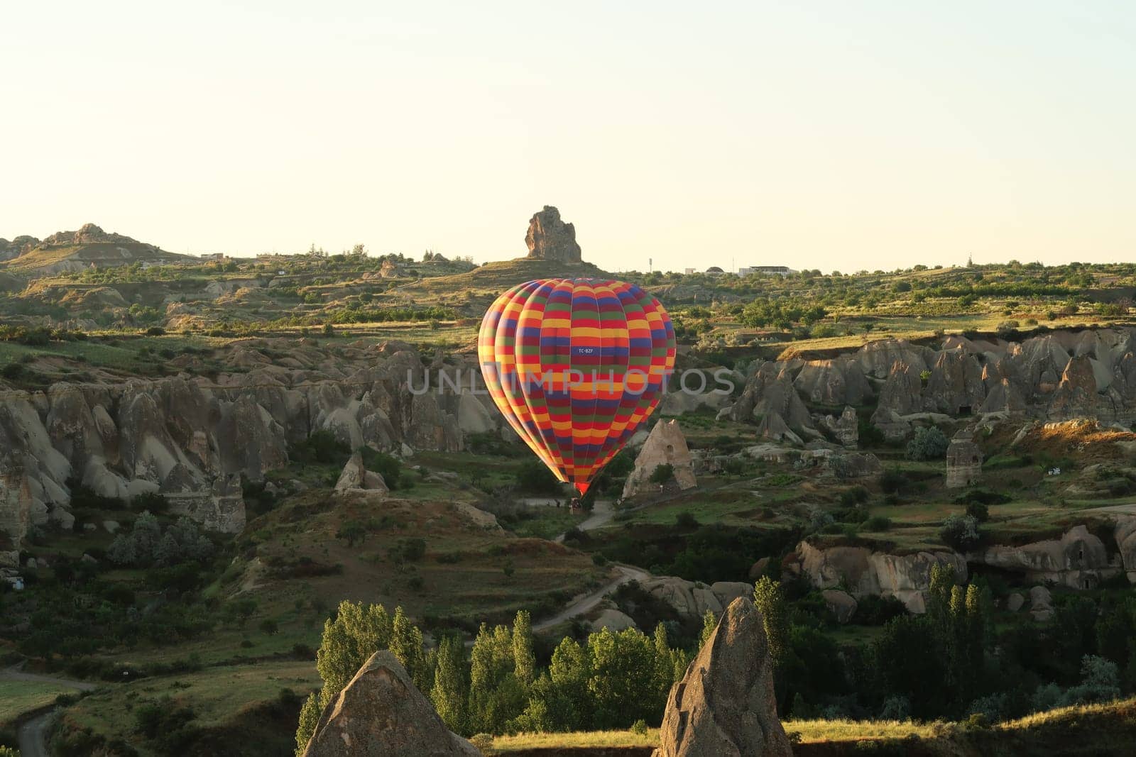 Colorful hot air balloon flying over the landscape of Cappadocia with its famous fairy chimneys, close to Göreme, Cappadocia, Turkey 2022