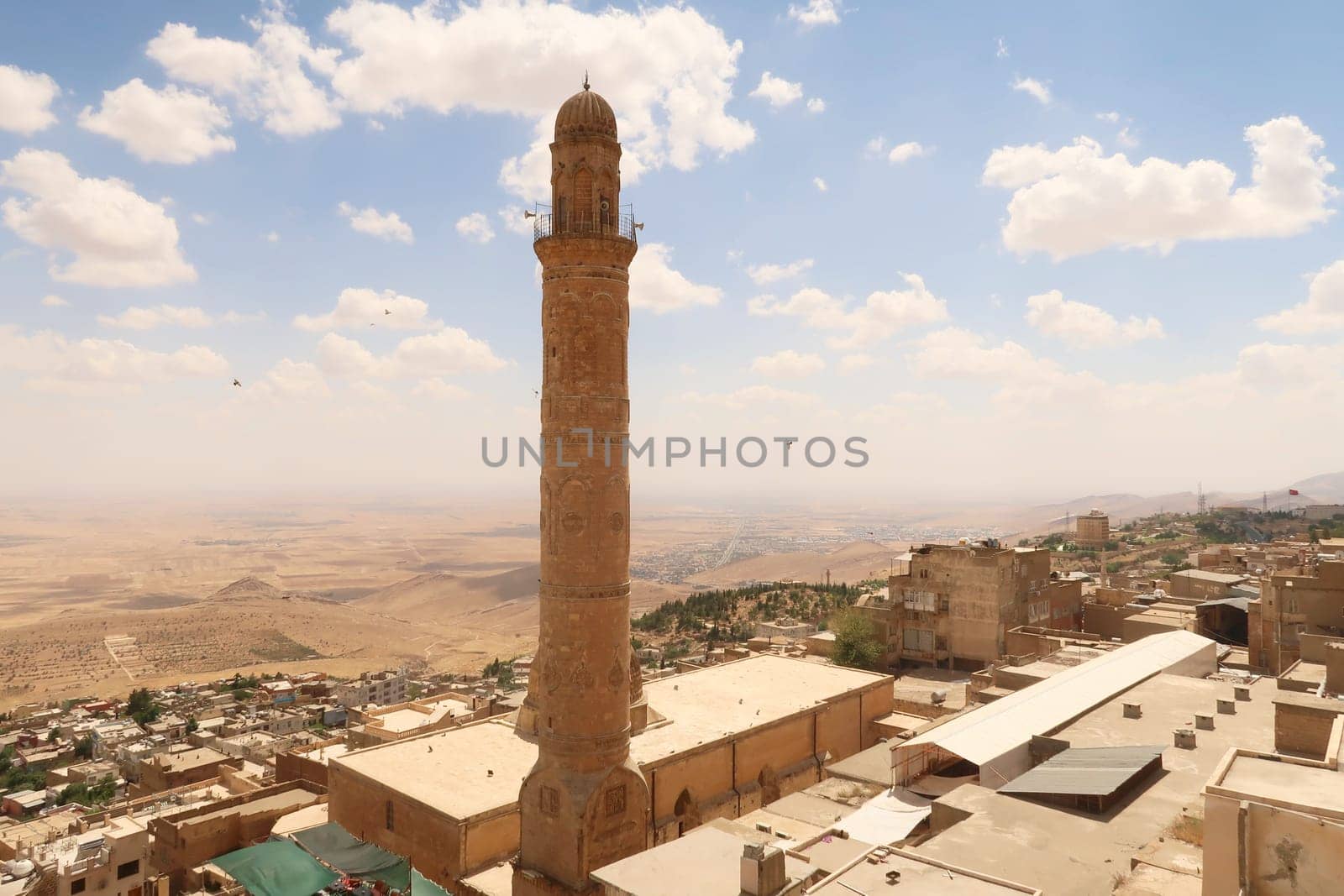 View onto the landscape of Syria from the old town of Mardin, with the minaret of the Great, Grand Mosque, Ulu Camii in the foreground, Mardin, Turkey 2022