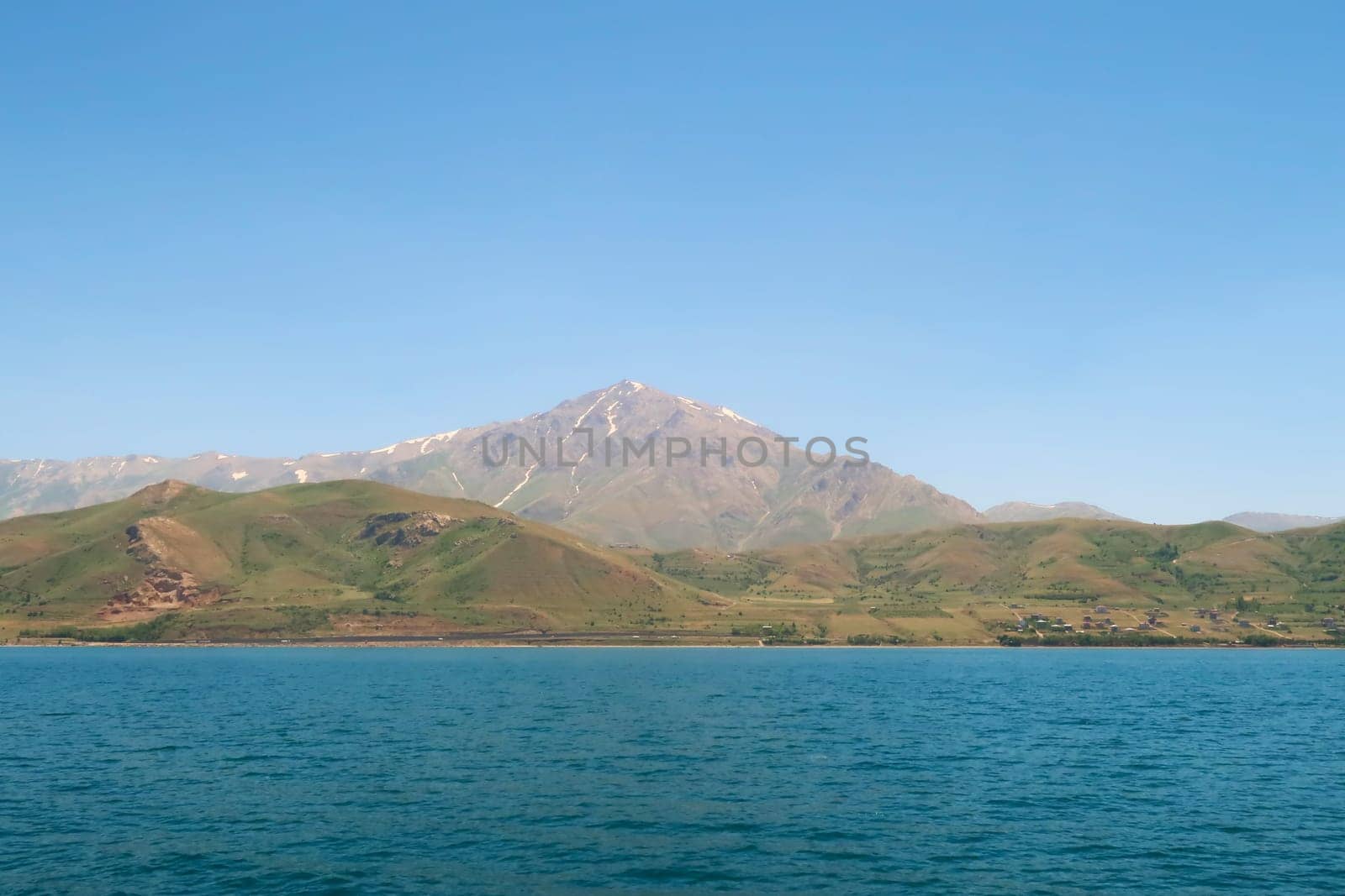 Mount Artos seen from Lake Van, Van Gölü, the intense blue color of the water in the foreground and the dormant volcano in the background, Van, Turkey 2022