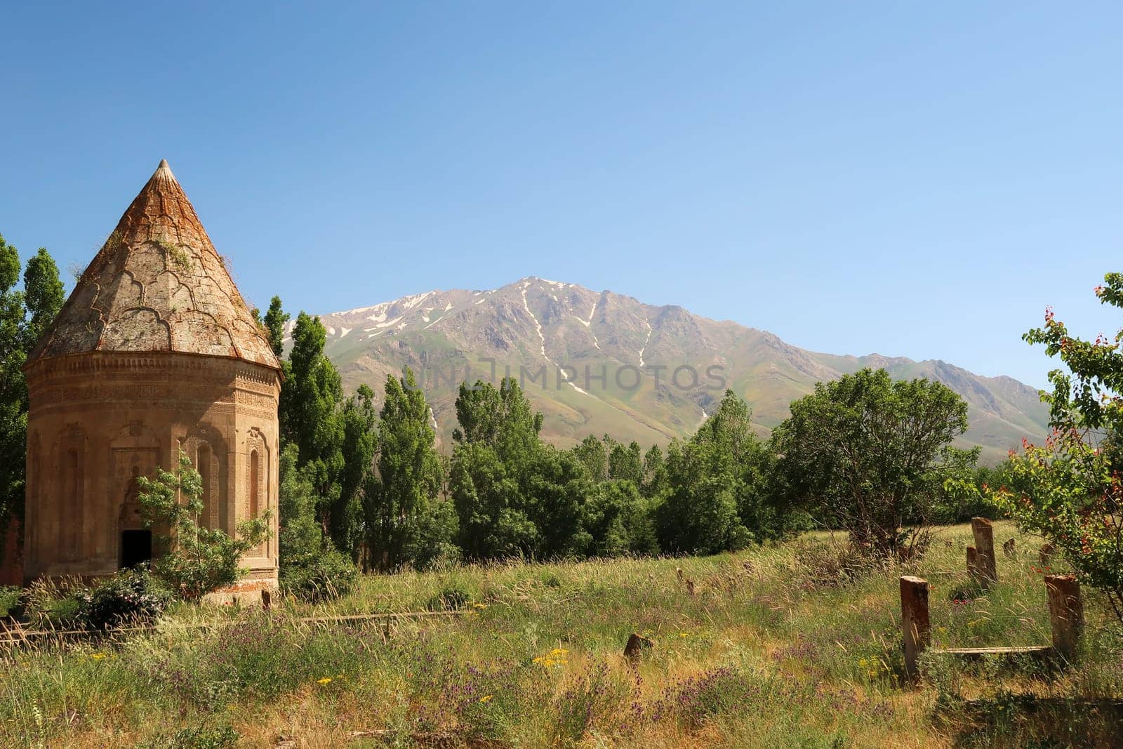 The Halime Hatun tomb, grave, mausoleum, Halime Hatun Kümbeti with the snow covered Mount Artos in the background and a few tombstones next to it, close to Lake Van, Van Gölü, Gevas, Turkey 2022