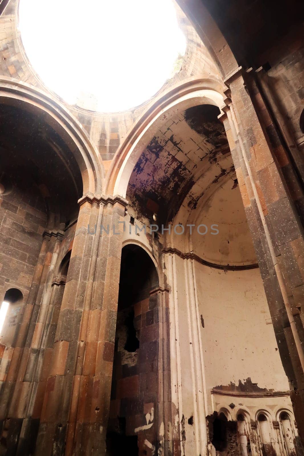 Inside of the Cathedral of Ani, Church of the Holy Mother of God, light is shining through the hole in the ceiling, at the ancient site of Ani, an abandoned ruined armenian city, close to Kars, Turkey 2022