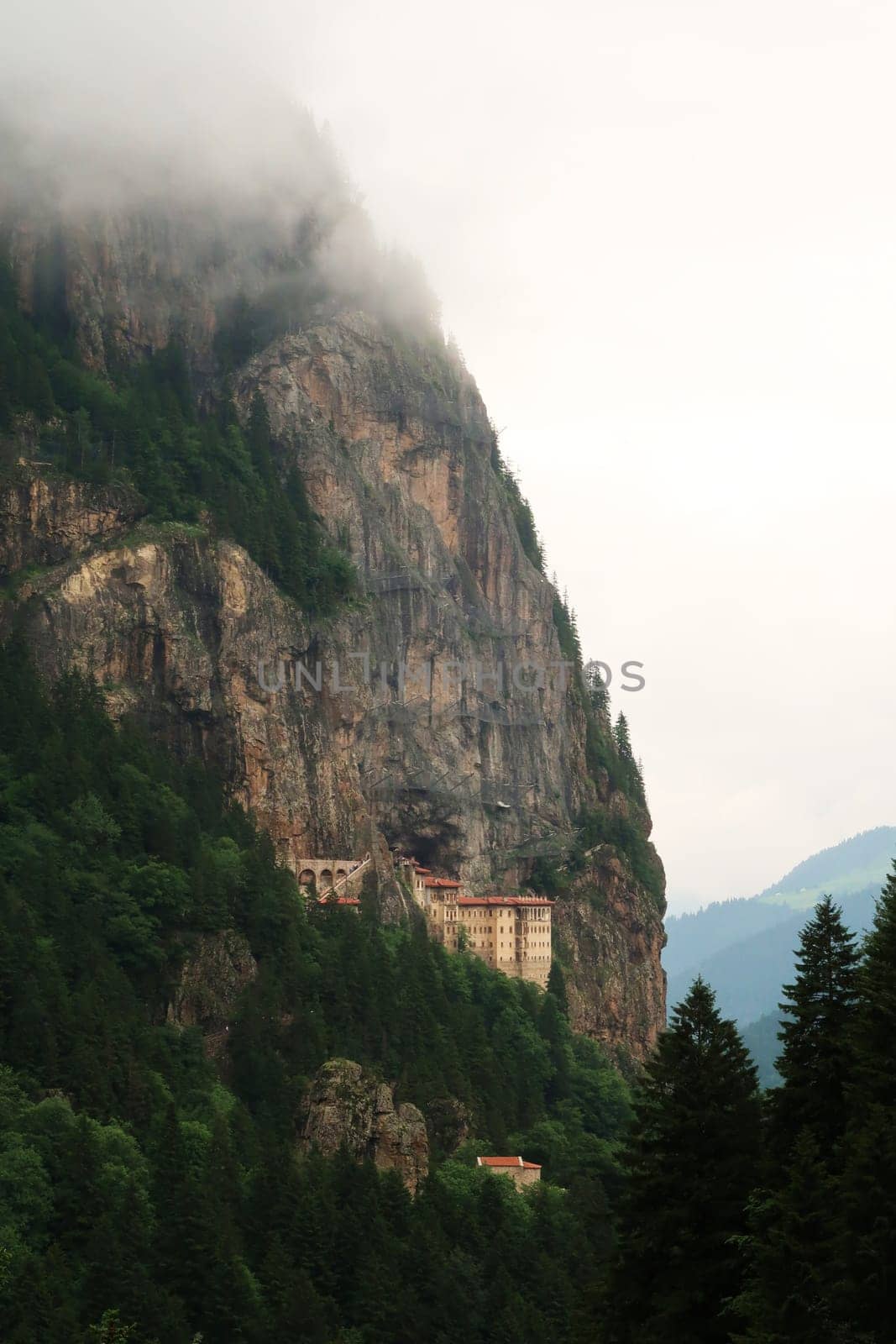Spectacular view onto the Sumela, Sümela Monastery, built on a cliff above a dense forest, fog coming up above the cliff, Trabzon, Turkey 2022