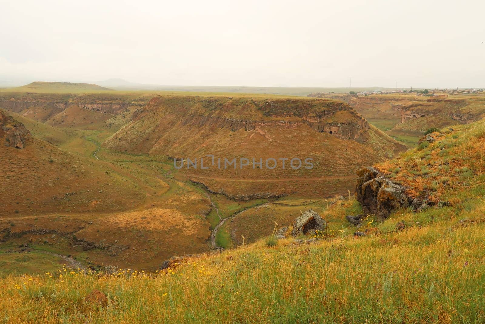 The Tsaghkotsadzor valley, gorge, canyon of the Alaca Cay river with man made caves next to the ancient site of Ani, an abandoned ruined armenian city, close to Kars, Turkey 2022