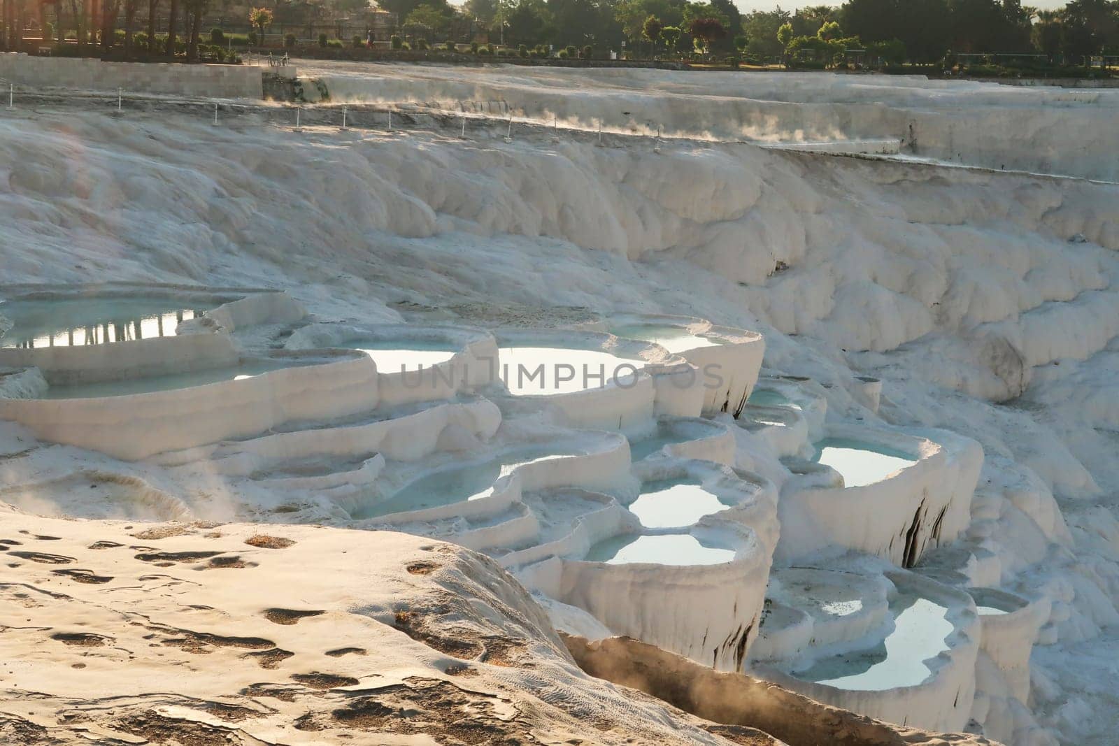 Steam coming up from the reflecting hot water in the travertines of Pamukkale early in the morning, Denizli, Turkey 2022
