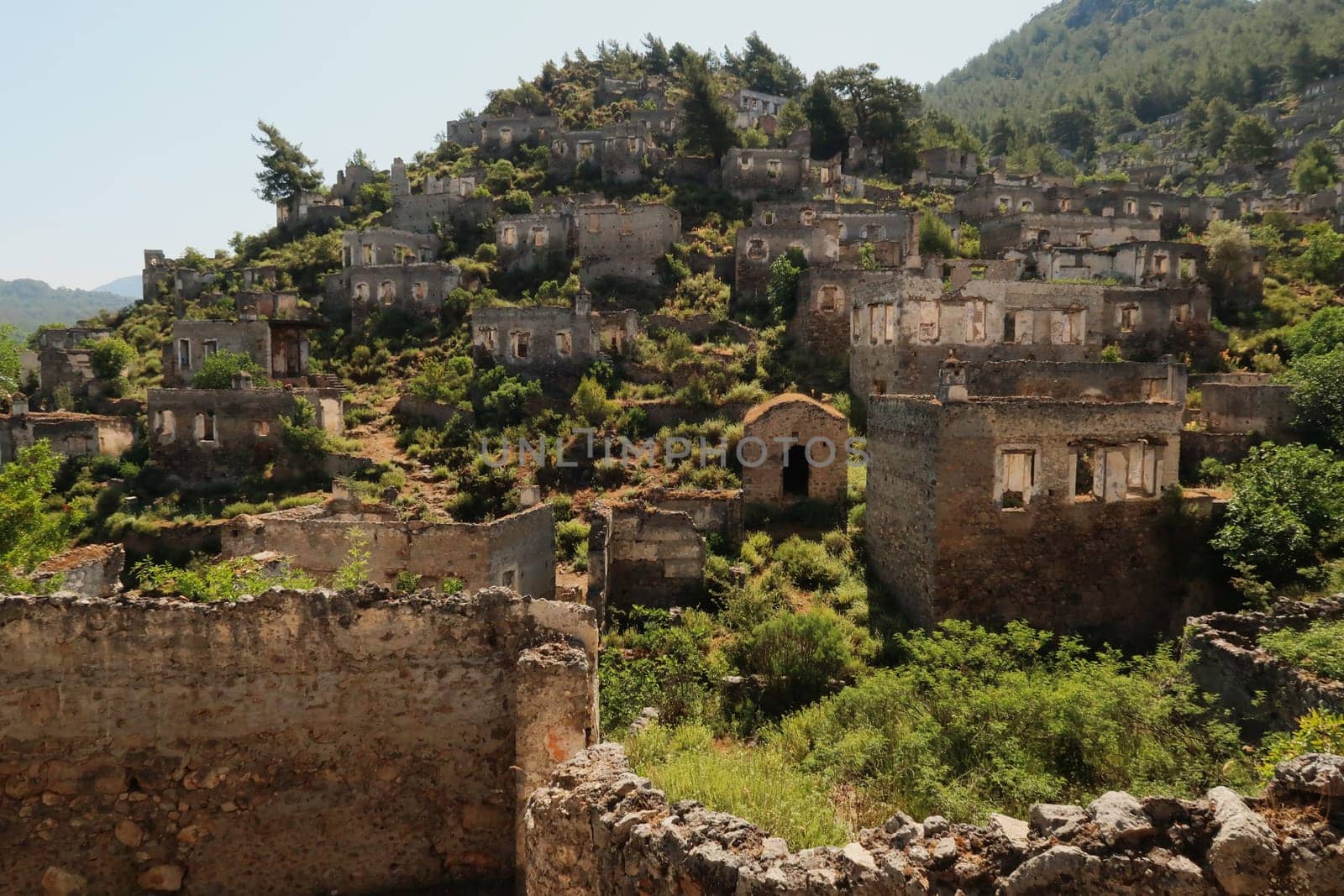 Ruins of houses on a hill in the abandoned village of Kayaköy, Livissi, close to Fethiye, Turkey 2022