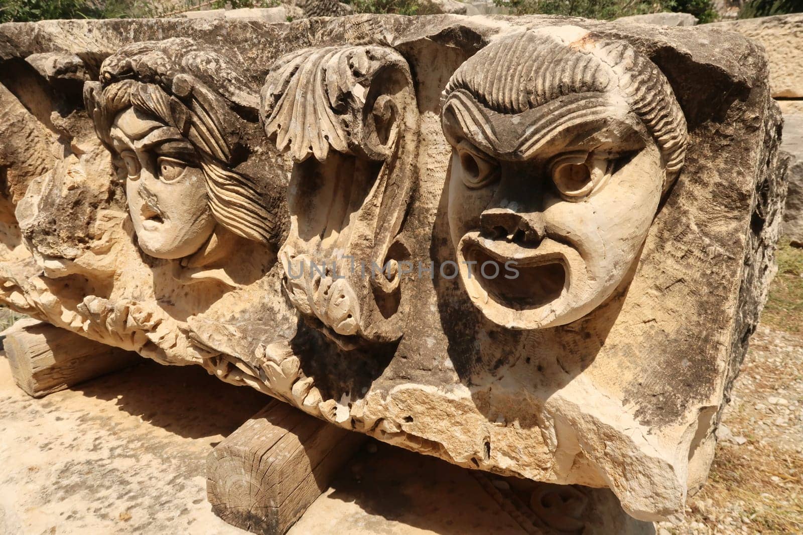 Big stone with ancient relief of three theater masks in the ancient town of Myra, near Demre, Turkey 2022