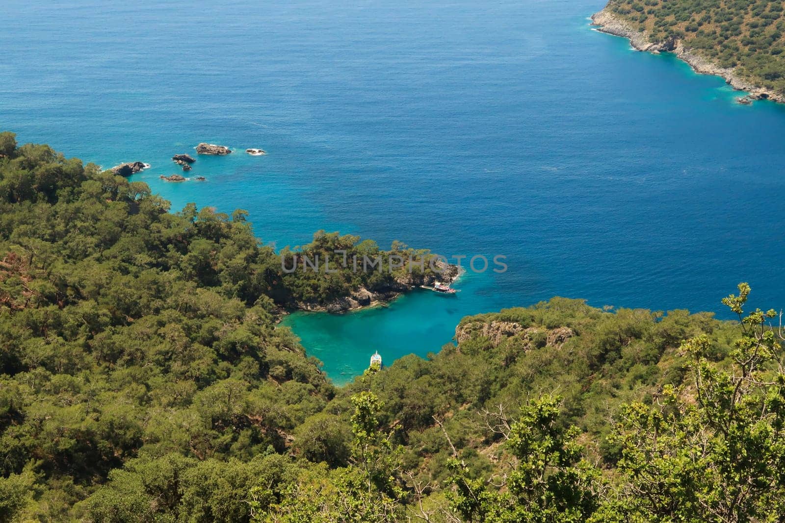 View onto the turquoise colored Mersinli Koyu Bay with an anchored boat in it, near Kayaköy, Fethiye, Turkey 2022