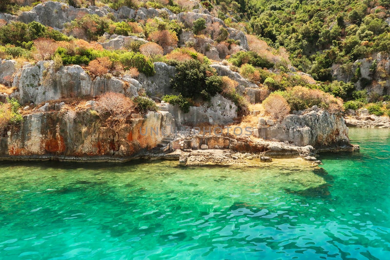 Stairs ending in the water next to submerged structures at the ancient sunken city of Kekova, Kekova Island, Demre, Turkey 2022