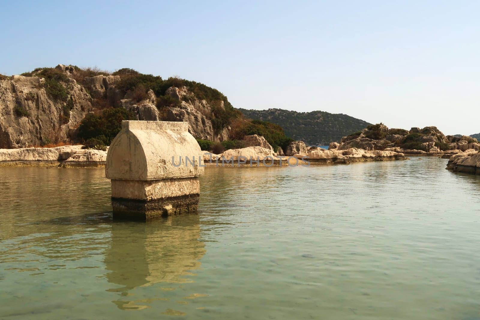 Sarcophagus standing in the shallow water close to the harbor of Kaleköy, close to Demre, Turkey 2022