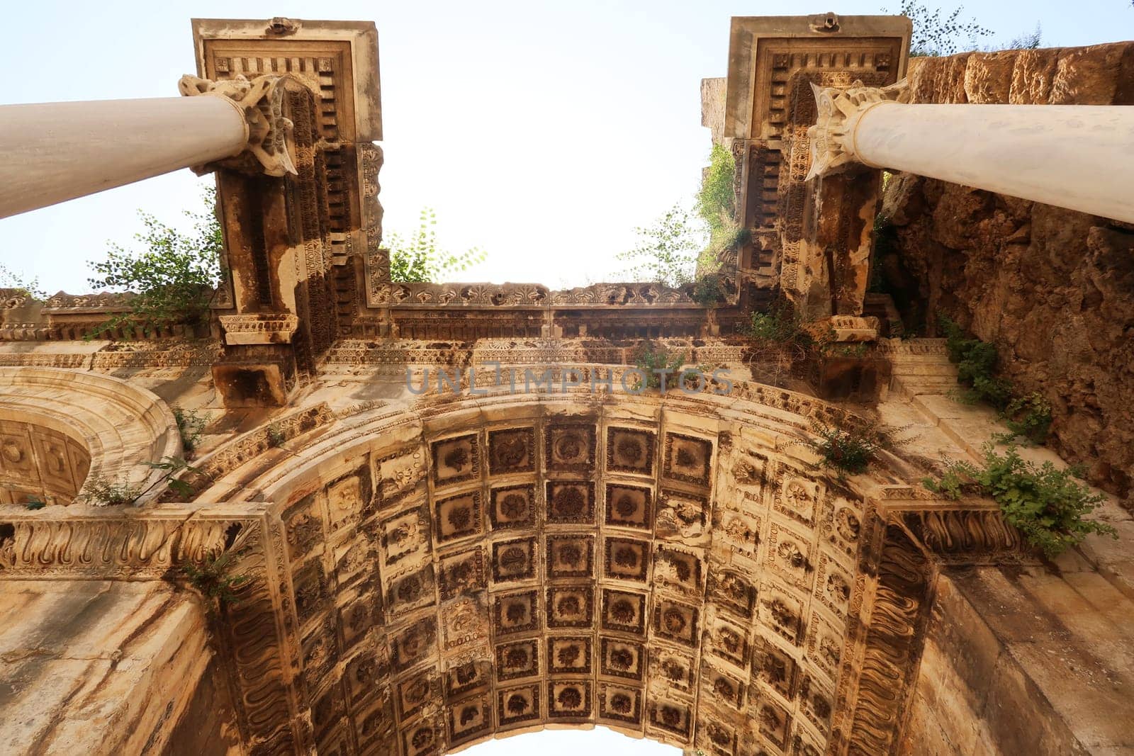 The ceiling of one of the entry arches of the Hadrians Gate sided by two roman columns, Antalya, Turkey 2022