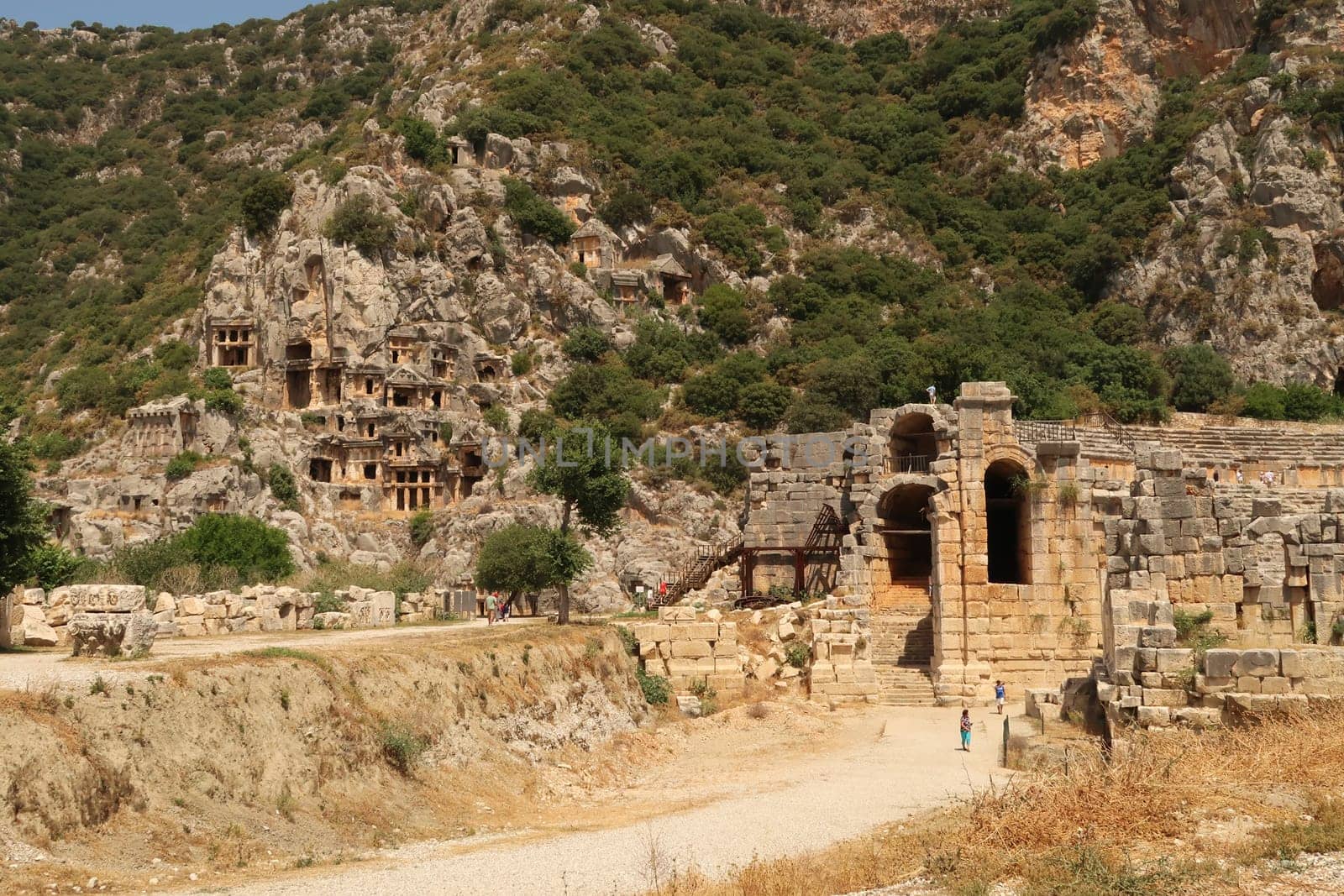 The ancient city of Myra with its rock-hewn tombs on the left and the entrance to its theater on the right, Demre, Turkey, 26th of May 2022
