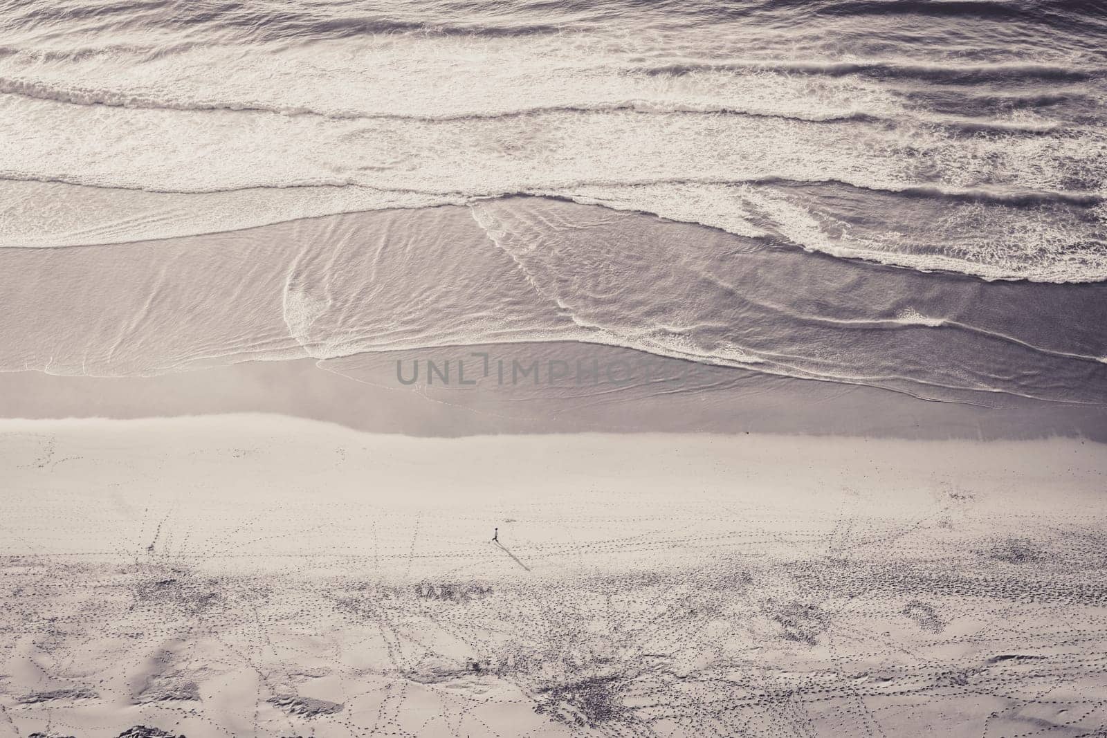 Black and white monochrome high angle shot of unrecognizable person on an empty beach