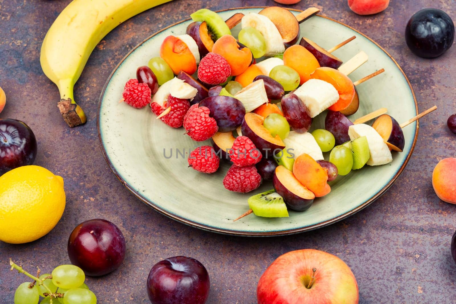 Colorful fruit skewers made from fresh fruits on wooden skewers.