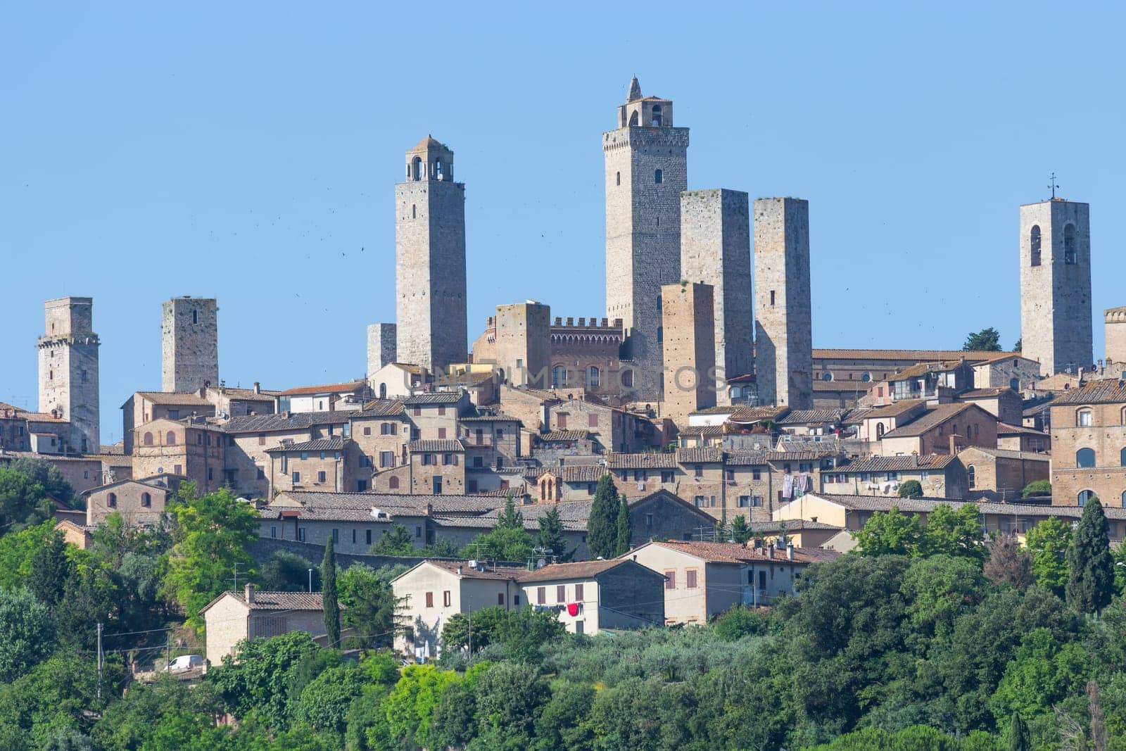 San Gimignano village, Italy - green countryside, blue sky, hill panorama with town and towers