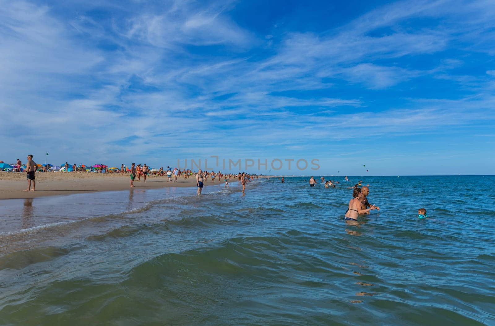 Tavira, Portugal - August 15, 2023: People at the famous beach of Tavira island in Tavira. This beach is a part of famous tourist region of Algarve.