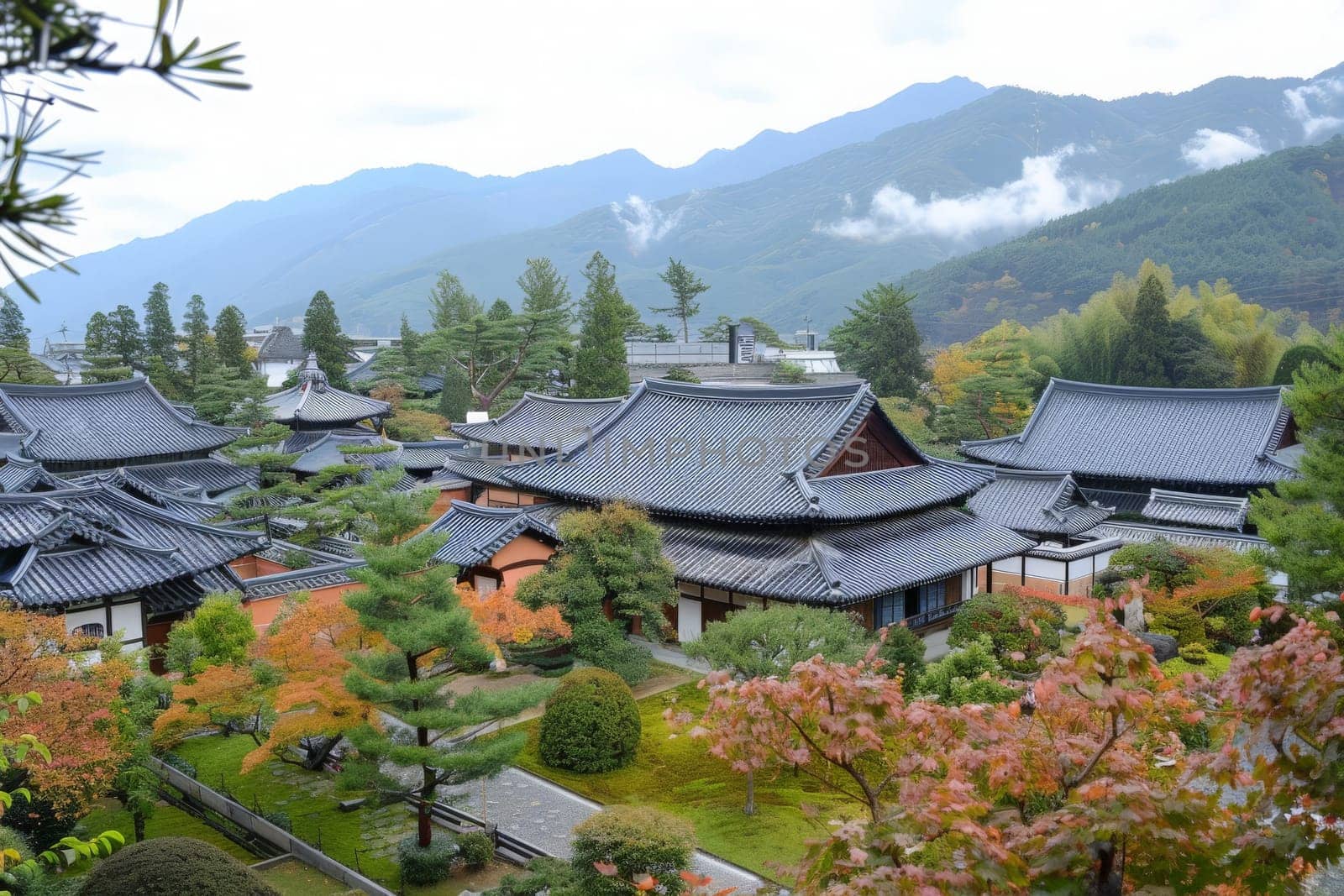 Traditional Korean architecture blends with vibrant fall foliage under a soft overcast sky.