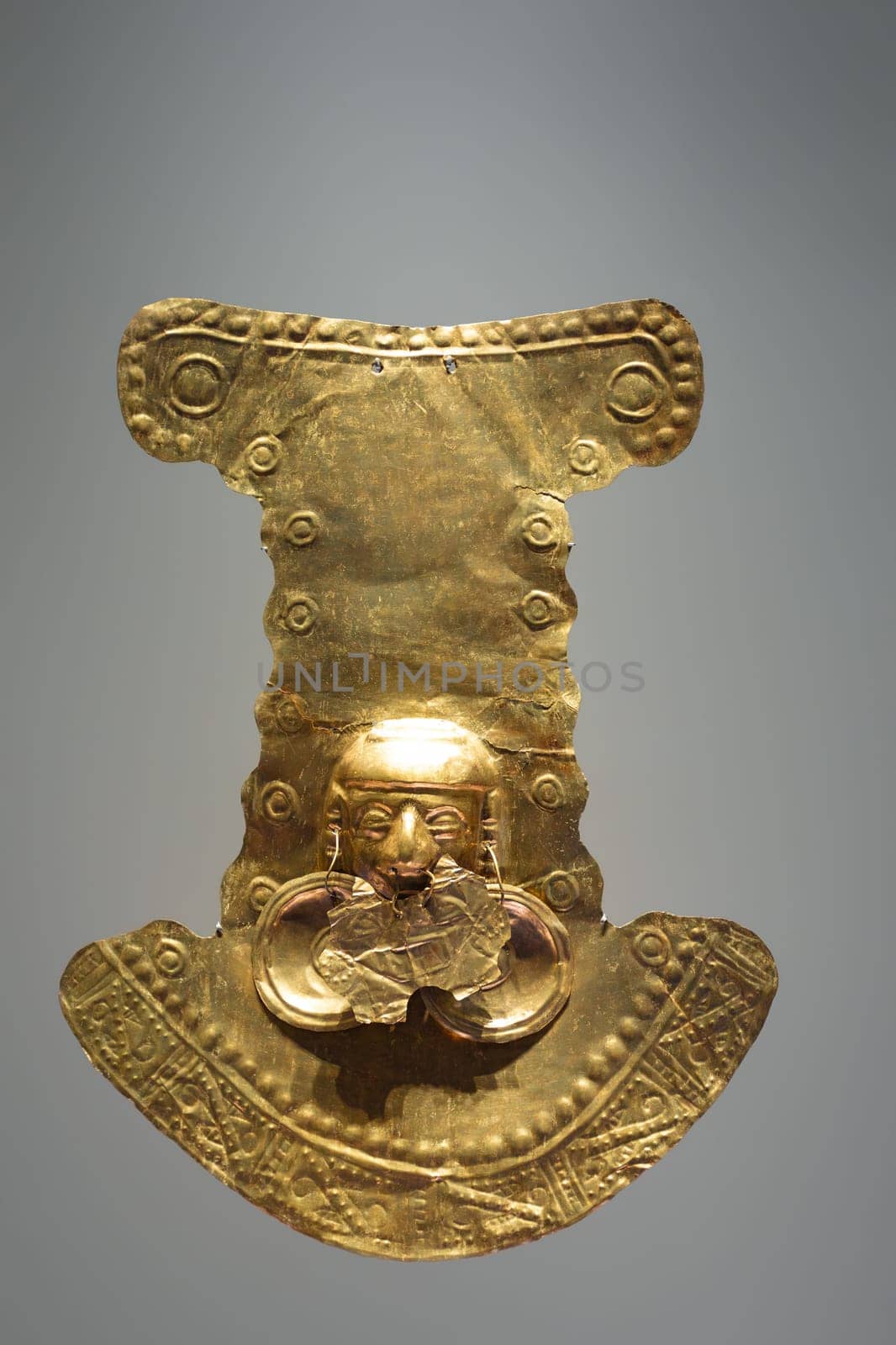 Pre-Columbian gold statuette in the Museo del Oro. Golden indigenous ornament from South American natives civilization. Famous Gold Museum, Bogota, Colombia.