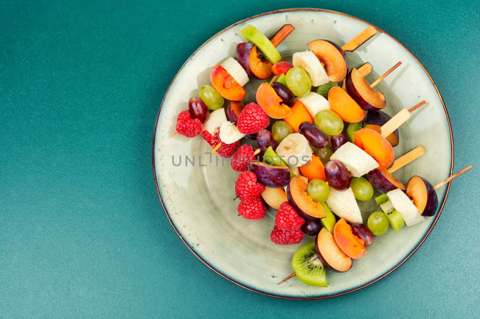 Raw fruit skewers of fresh fruits on wooden skewers. Party healthy snack