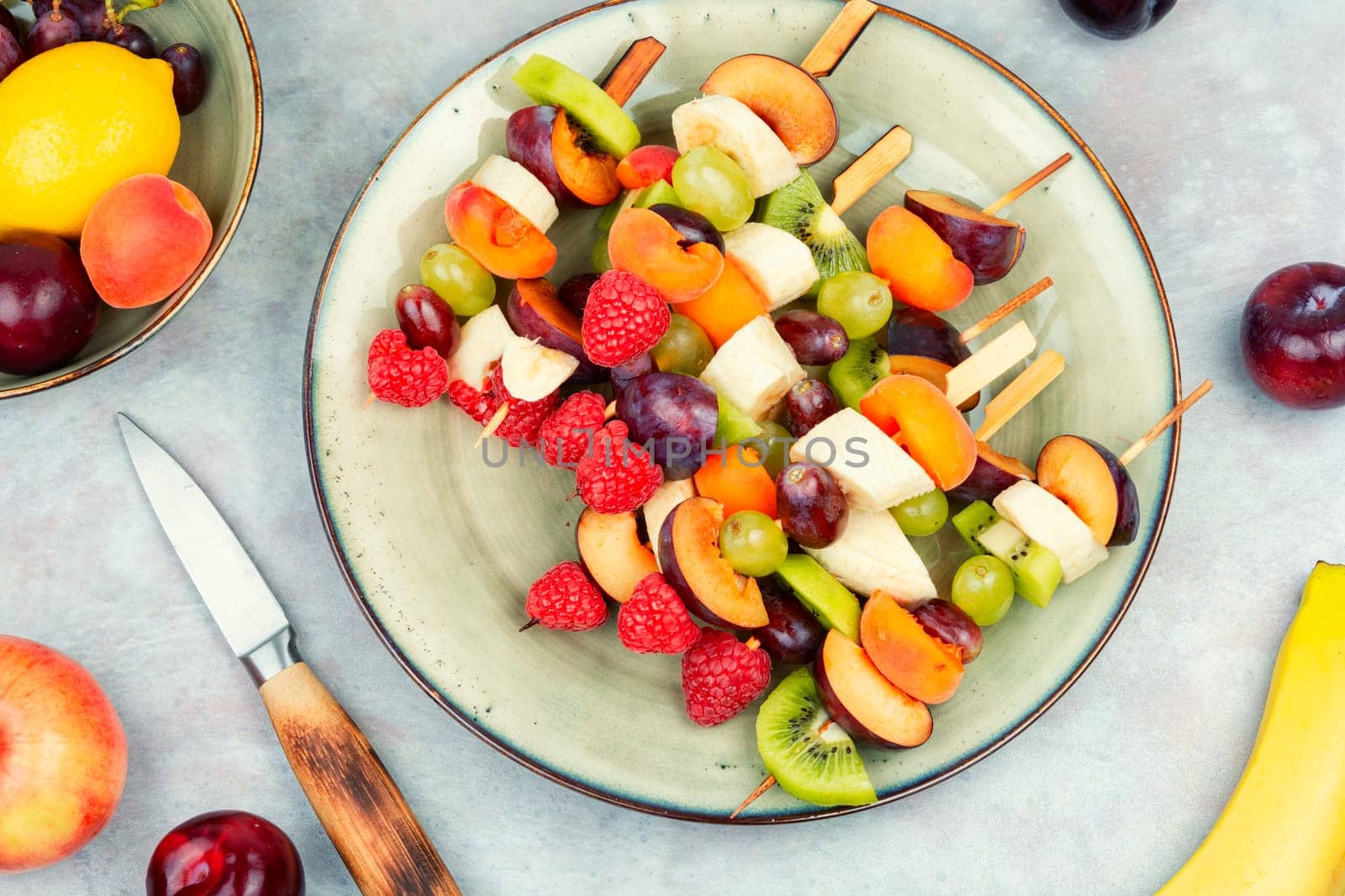 Raw fruit skewers of fresh fruits on wooden skewers. Party healthy snack